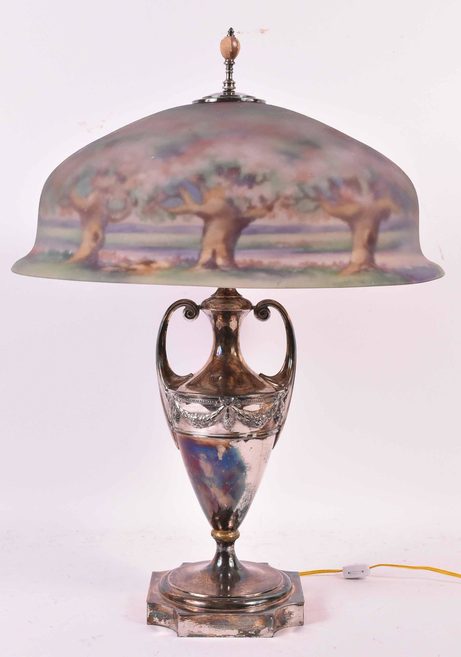 W. Macy Pairpoint Reverse Painted Table Lamp: William Macy, with flowering tree decoration, mounted on associated silver plated base. Chips to inside of glass. Overall: 27-1/2"h x 20"dia.