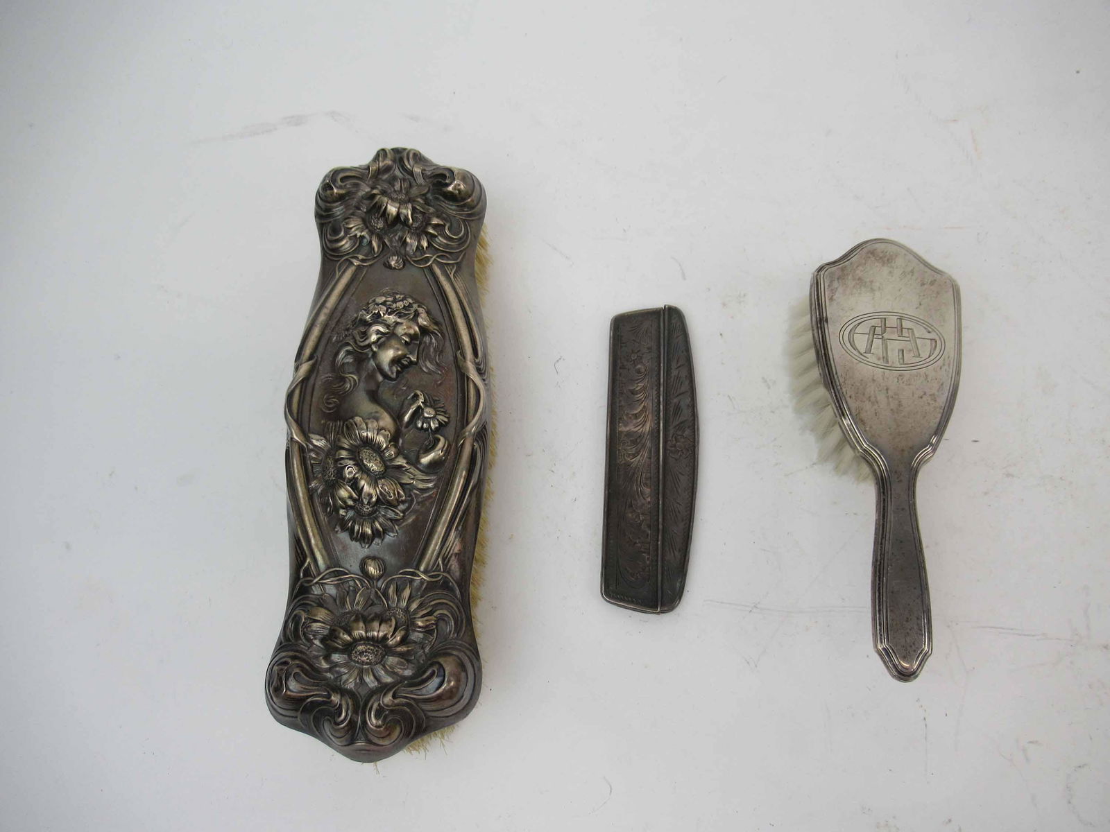 Victorian Sterling Silver Clothing Brush: Victorian Sterling Silver Clothing Brush with central embossed figure of woman and daisy . Together with a Sterling silver small comb missing teeth and a Tiffany & Co sterling silver brush. Used condi