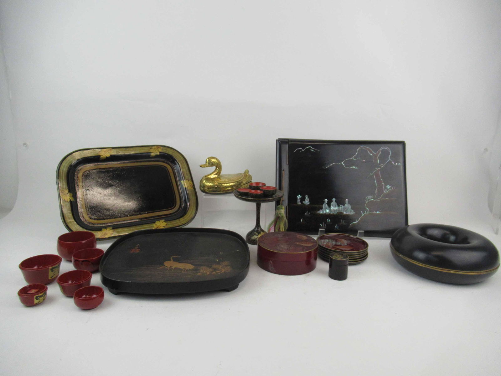Group of Assorted Black Lacquered Table Articles: Group of Assorted Black Lacquered Table Articles. Including Coasters, tray, circular box, nesting dolls, compote and cups, trinket box, wooden book case, metal tray and duck box.
