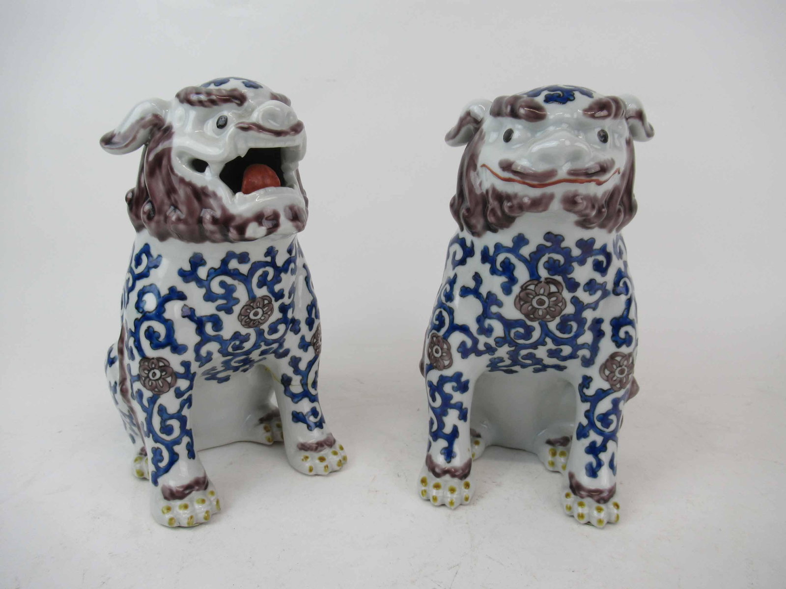 Pair of Chinese Foo Fu Dogs: Pair of Chinese Foo Fu Dogs with blue and white decoration. Used condition, repair to leg. 8 1/2" x 5" wide x 7" deep