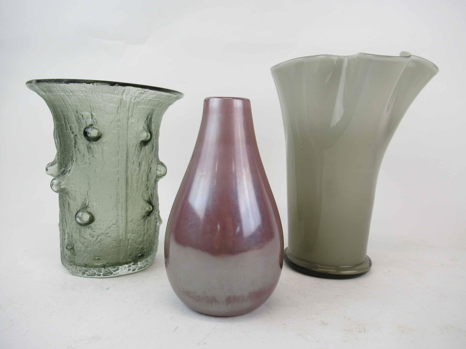 Timo Sarpaneva Finlandia Littala Glass Vase: Timo Sarpaneva Finlandia Littala Blown & Moulded Glass Vase, signed & numbered 3356 and measures 7 3/4" high x 6 1/2" wide. Together with a smoky fluted vase and a pink iridescent vase from West Elm,