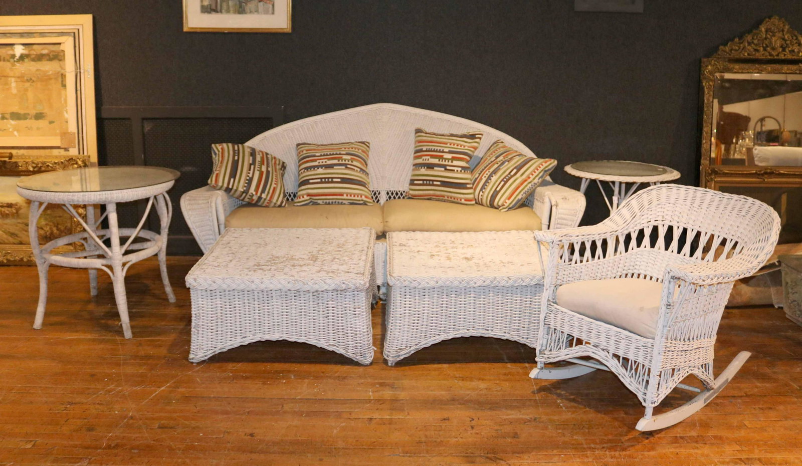Group of White-Painted Wicker Furniture: Comprising, a large settee, a rocking chair, two ottomans, and two circular tables. Settee: 40-1/2"h x 7'3"l x 29"d