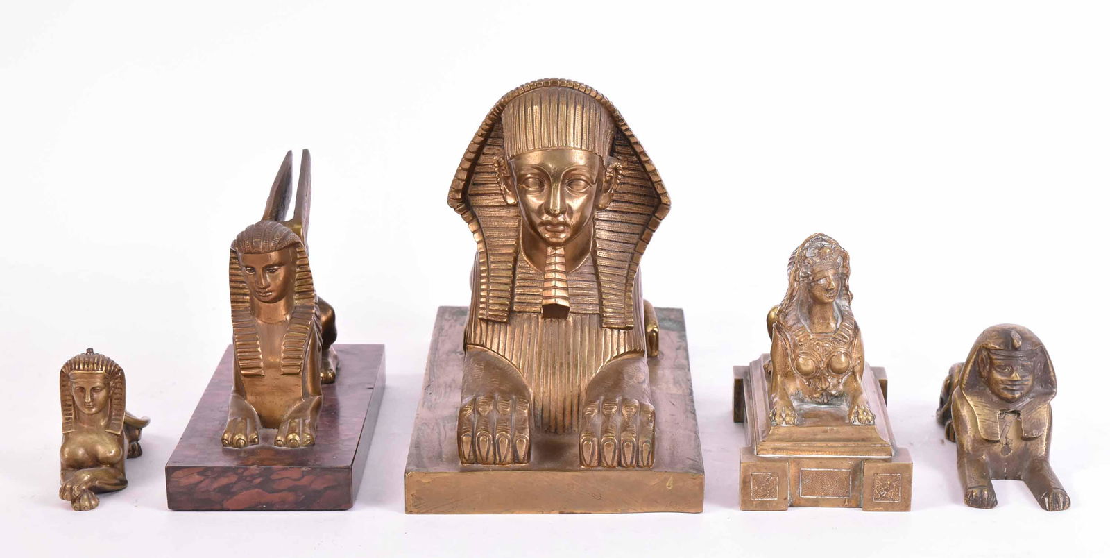 Five Bronze and Gilt-Metal Sphinx Sculptures: Including, One from the Crystal Palace, inscribed "Escalier de Cristal Paris", one fitted as an inkwell, and one mounted on marble base. Largest: 7-1/4"h x 9-1/4"w x 5-1/4"d