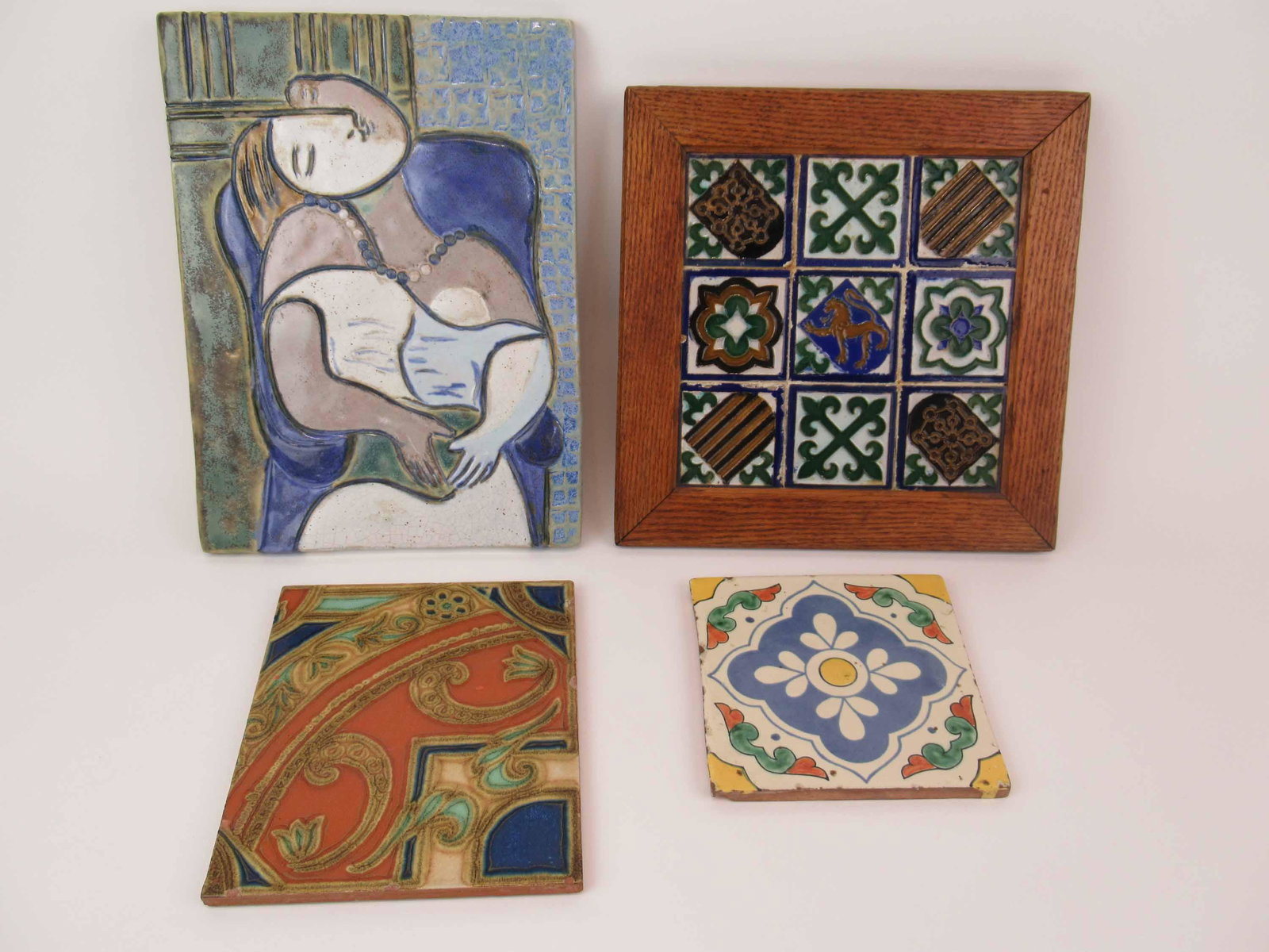 Group of Four Decorative Tiles: Group of Four Decorative Tiles. Including a modern tile of woman, oak framed set of tiles and two assorted tiles. Used condition. Largest tile 12 1/4" x 9 1/4"