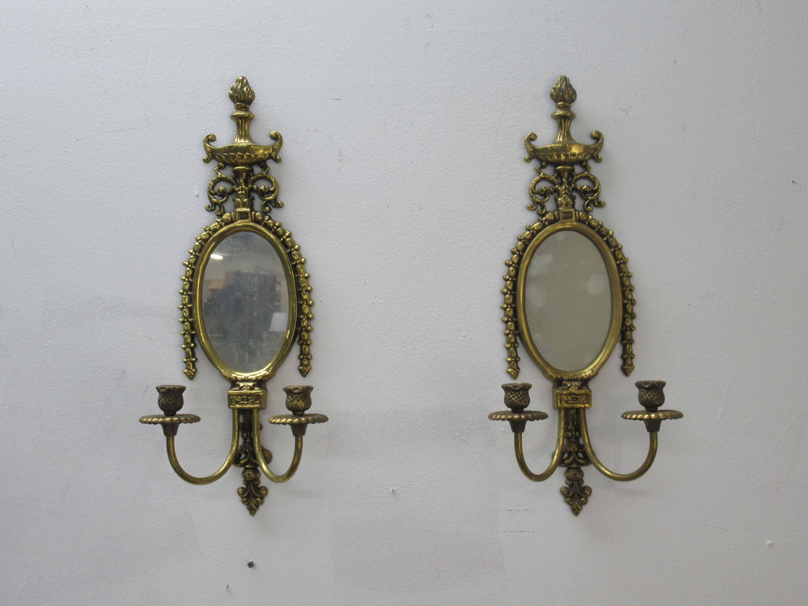 Pair of Neoclassical Style 2 Light Wall Sconces: A Pair of Neoclassical Style 2 Light French Wall Sconces featuring urn form finial with flame and acanthus decoration. Used condition, wear, worn, missing prisms, 23" tall x 9 1/2" wide x 5 1/4" deep