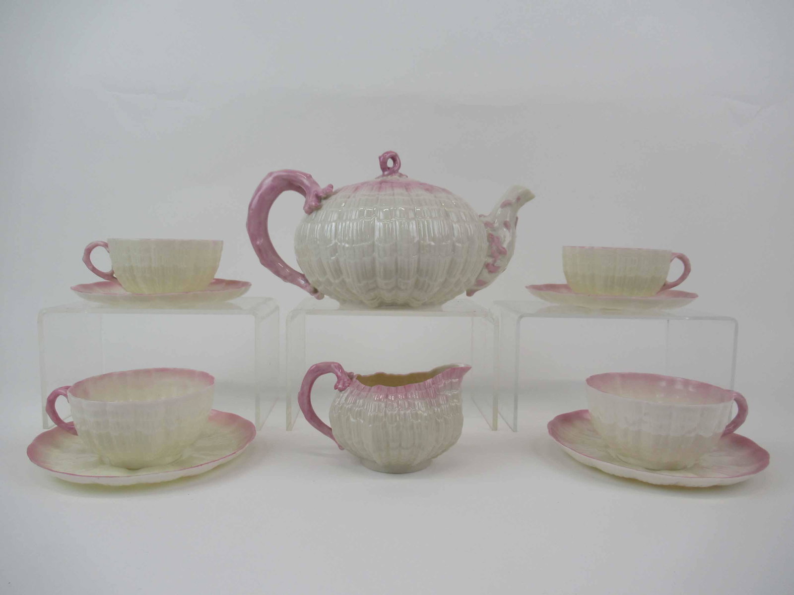 Belleek Black Mark Tridacna Pink Tea Set: Belleek Black Mark Tridacna Pink Tea Set. Comprising, tea pot, 4 cups one has a chip, one has a crack and saucers, and creamer small chip, Used condition.