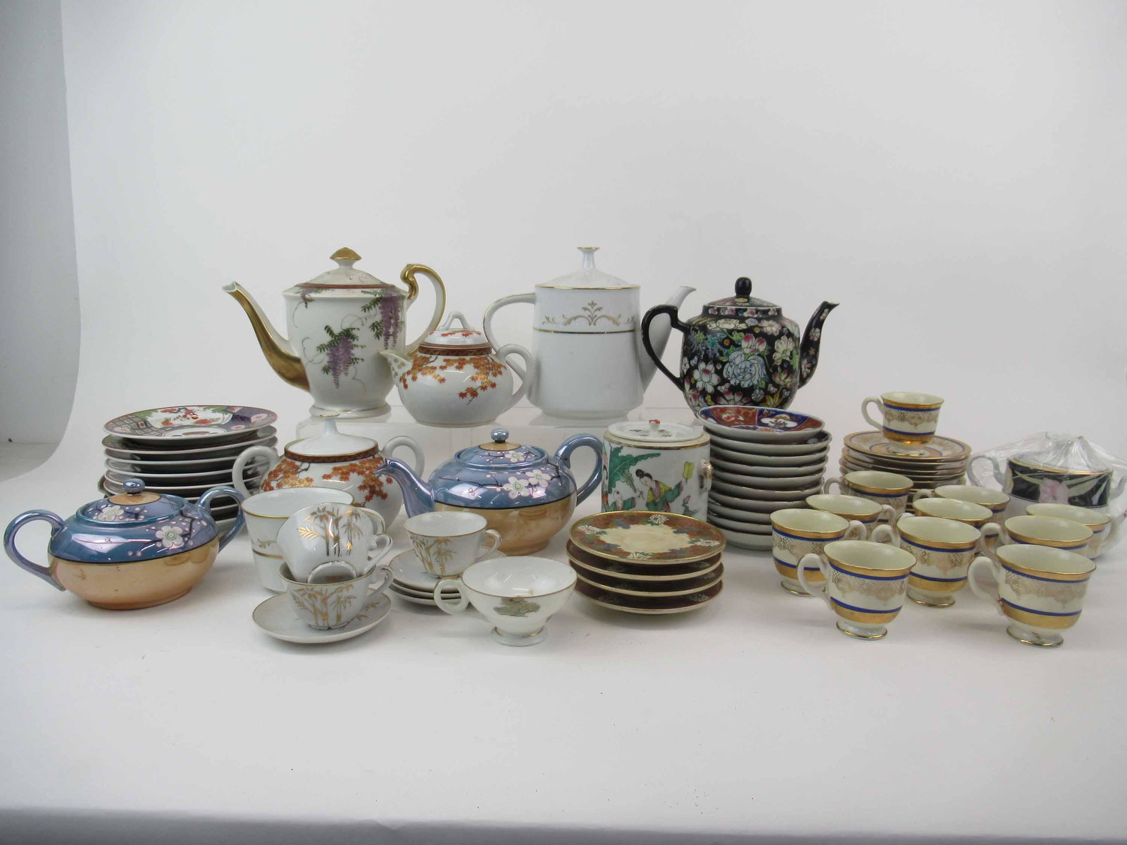 Group of Assorted Porcelain Table Articles: Group of Assorted Porcelain Table Articles. Including tea pots, creamer, sugar, saucers and demitasse cups and saucers. Together with similar table articles. Used condition, wear, worn, chips, cracks.