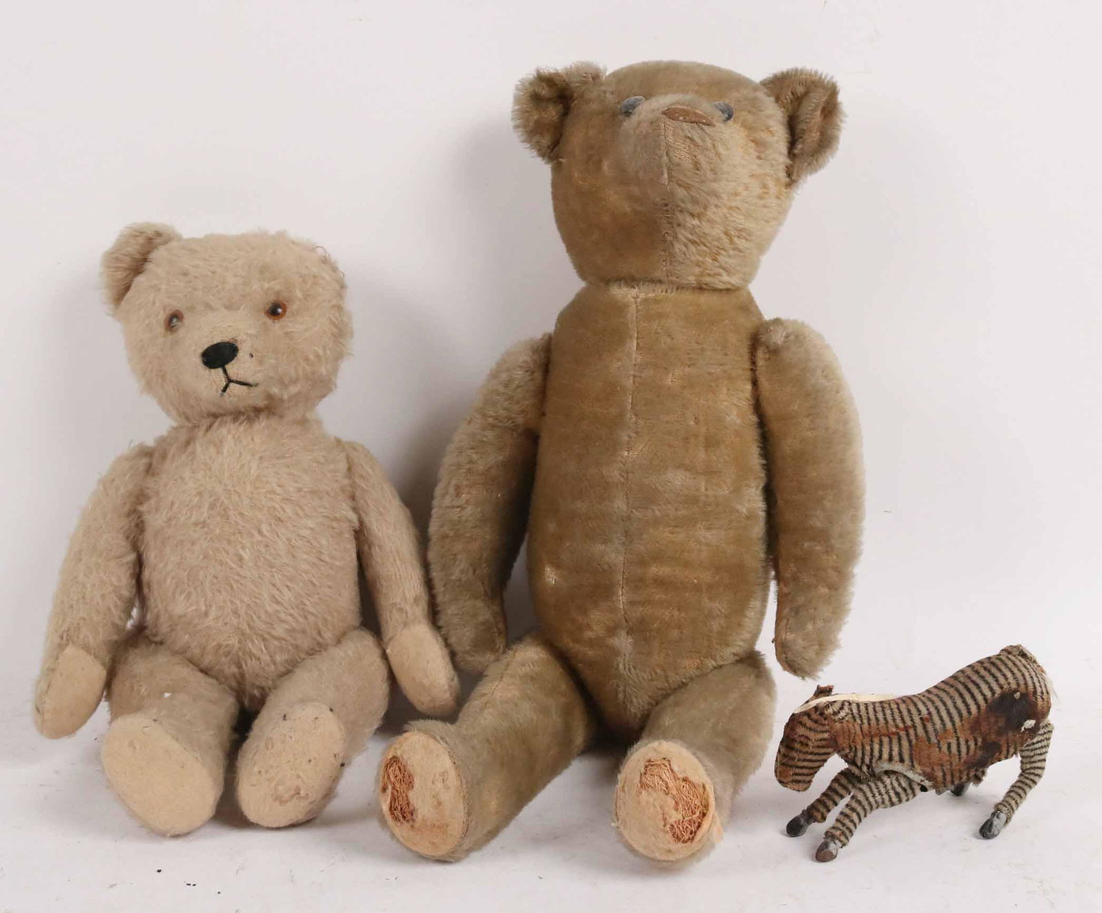 Two Vintage Steiff Teddy Bears: Together with a mechanical Zebra toy. Sizes: Teddy Bears 13"h & 20"h, Zebra 3 1/2"h x 5 1/2"l Condition: All three have wear and are missing parts.
