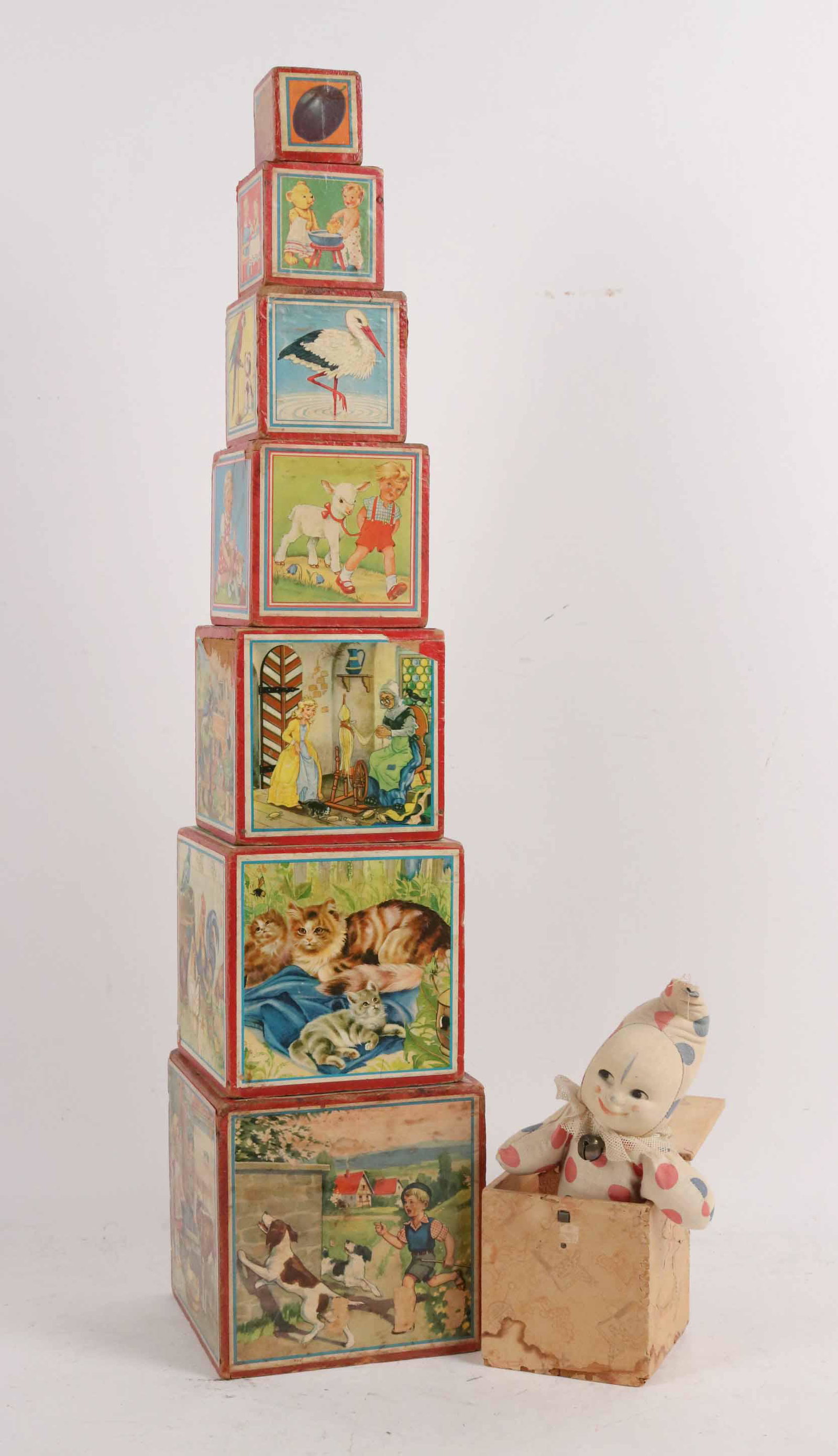 Set Nesting Blocks: Together with an early Jack in the box, wood covered with paper litho, Jack is a cloth covered clown. Size: Largest block 7 1/4"h x 7" square, Jack 4 3/4"h x 4 1/2" square Condition: Jack box has wate