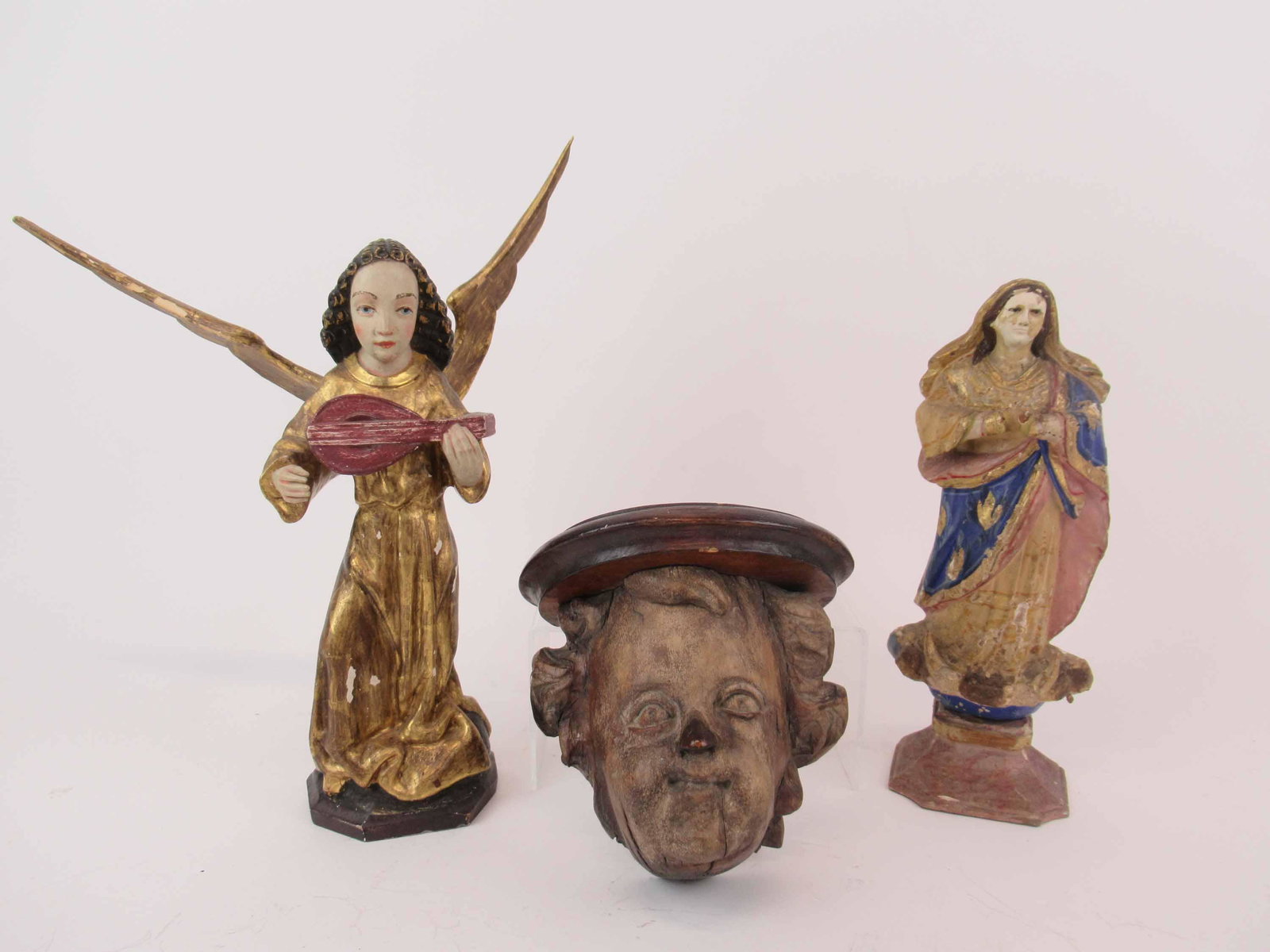 Italian Putti Mask Form Wall Bracket Shelf: Italian Putti Mask Form Wall Bracket Shelf. Together with polychrome gilt decorated wooden angel and polychrome carved wooden Madonna. Used condition, wear, worn, paint loss, chips. 5 1/2" long x 6 1/