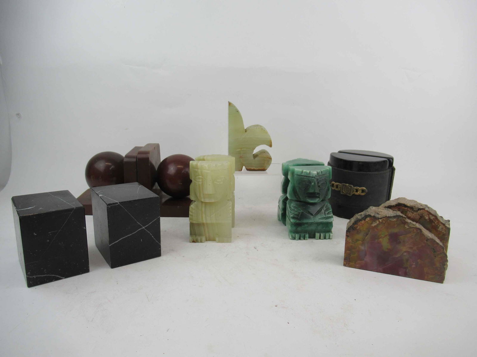Group of Assorted Bookends: Group of Assorted Bookends. Including, two onyx Aztec, pair of black granite, polished stone, leather trimmed with brass buckle, and wooden bookends. Used condition, wear, worn, chips.