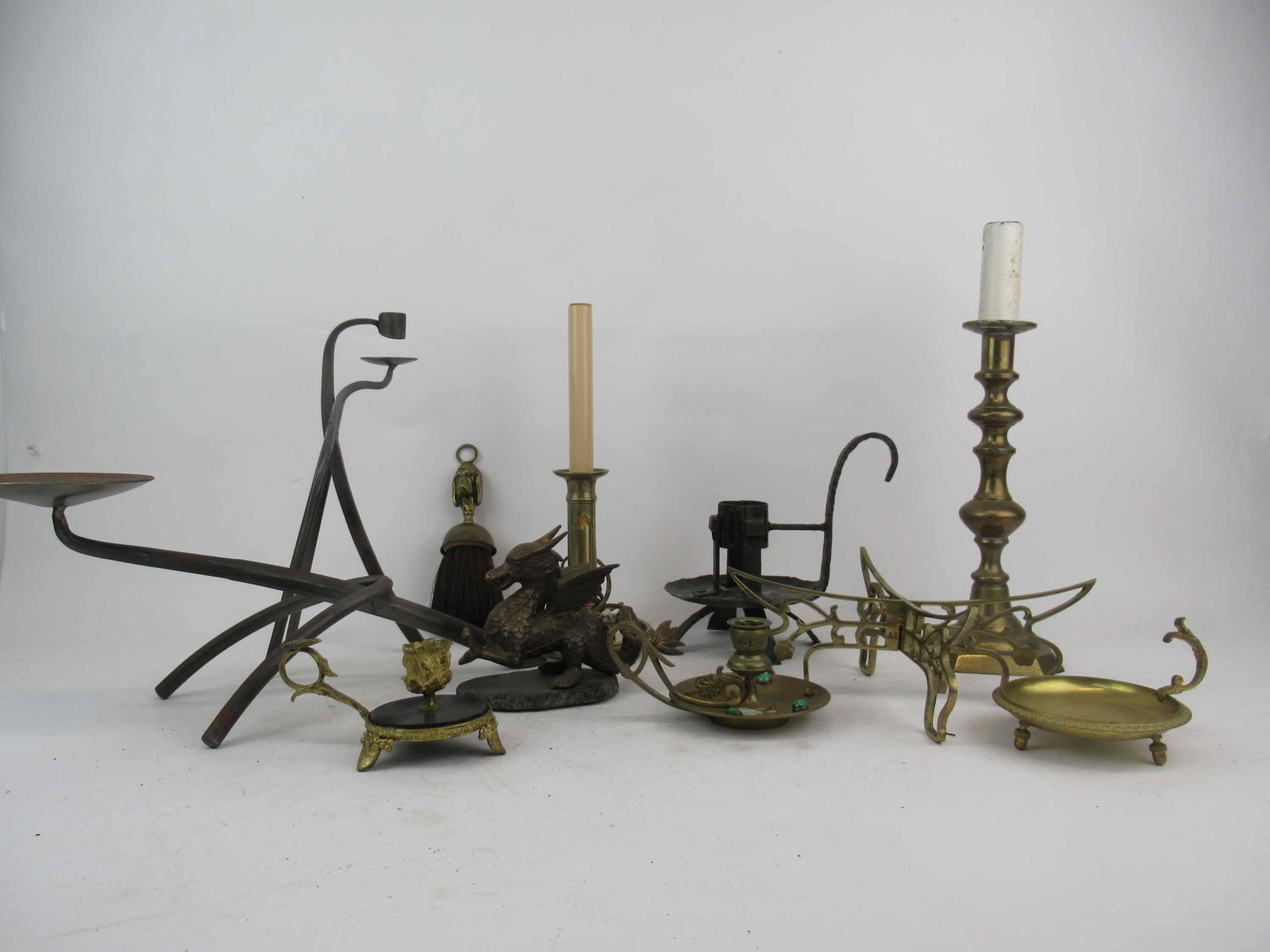 Group of Assorted Brass Table Articles: Group of Assorted Brass Table Articles. Including lamps, Figural hound dog table brush, candlesticks, Griffin and Steal candelsticks. Used condition, wear, worn.