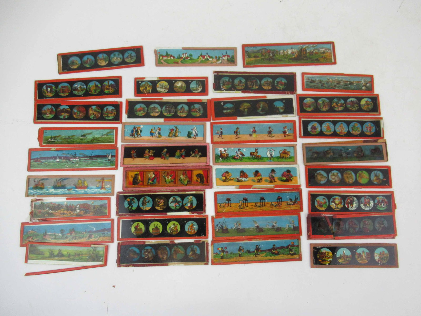 Group of Assorted German Magic Lantern Slides: Group of Assorted German Magic Lantern Slides. Including, battle scenes, fairy tales and around the world scenes. Used condition, wear, worn. largest 6 3/4" long x 1 3/4 and smallest 5 " x 1 1/4"
