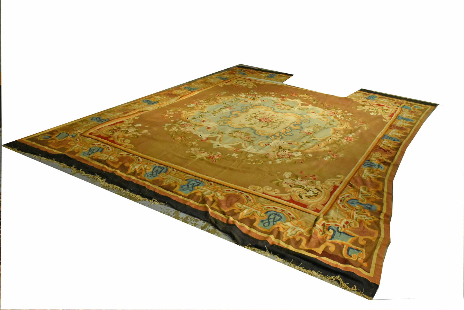 Aubusson Carpet: In two pieces, border was removed and center mounted on new backing, lacking section of border. Stains and losses. Apx. 13'1"l x 11'1"w (center section) 18'2"l x 13'11"w, overall