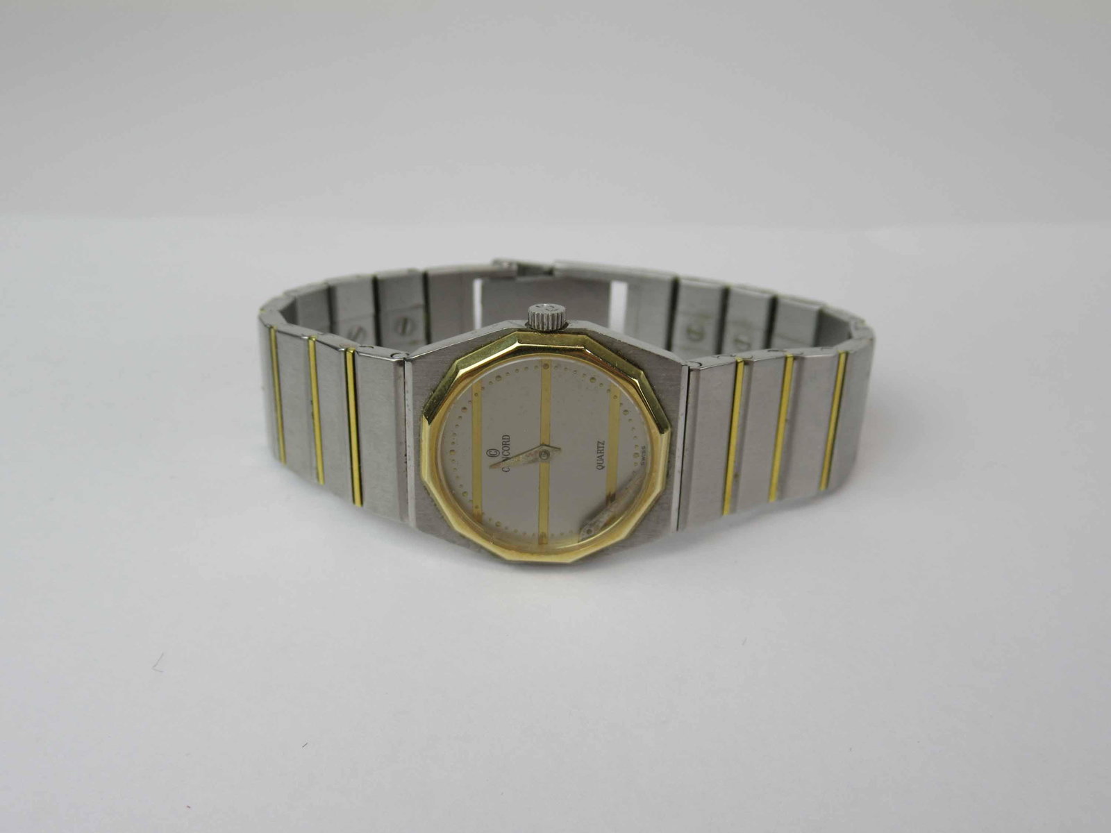 Concord Mariner Sg 18K/Steel Ladies Watch: Swiss Quartz Movement (Battery powered) Ultra thin ladies size model. 18K gold bezel. Serial Number 15 62 145 V14 680157. Condition: Minute hand not attached but in case face. Not in working condition