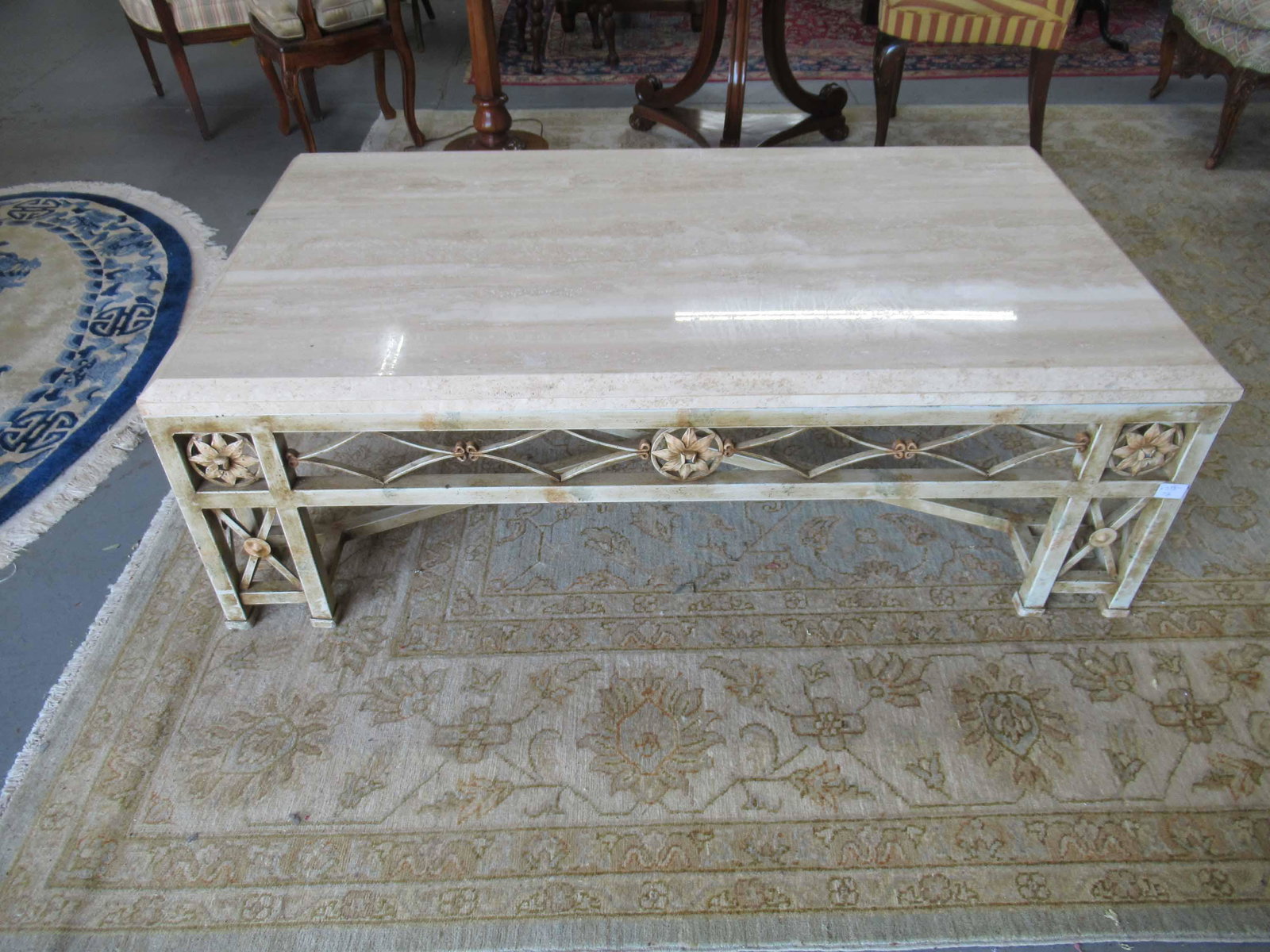 Italian Travertine Marble Top Coffee Table: Italian Travertine Marble Top Coffee Table. Resting on floral decorated painted metal base. Used condition, wear, worn. 54" long x 30" wide x 17" tall