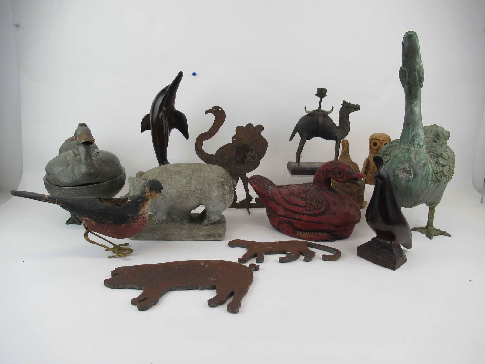 Group of Assorted Animal Figures: Group of Assorted Animal Figures including carved wooden duck with lid, pewter standing duck with lid, camel candlestick holder, iron pig, cat and ostrich, cement garden pig, hardwood dolphin and seal