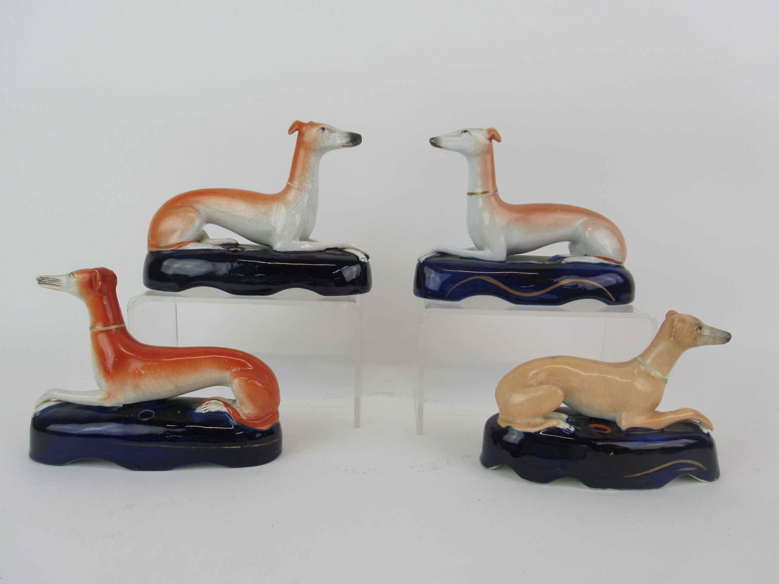 4 Assorted Staffordshire Whippet Pen Holders: 4 Assorted Staffordshire Whippet Pen Holders. Used condition, flea bite to one base, largest 6 1/2" long x 5" tall