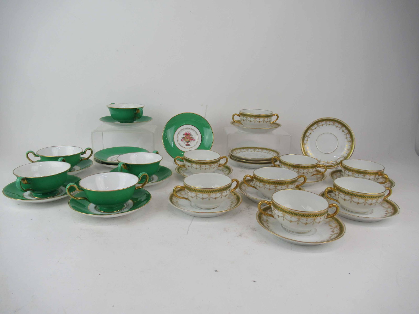 Eight Haviland Limoges Bouillon Cup & Saucer Sets: Eight Haviland Limoges Bouillon Cup & Saucer Sets in the pattern H868 having green and gold swags together with five Spode bouillon cup and saucer sets with urns and flowers, R8415, c.1920's; used con