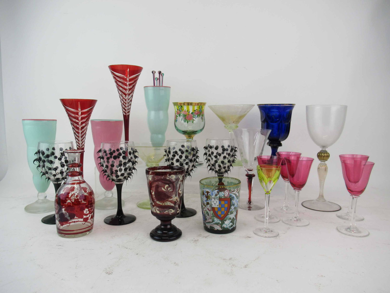 Group of Contemporary and Antique Glassware: Group of Contemporary and Antique Glassware including MacKenzie-Childs water goblet, two Gilmor Art Glass signed glasses, five cranberry glass cordials, three soda glasses, two cranberry champagne flu