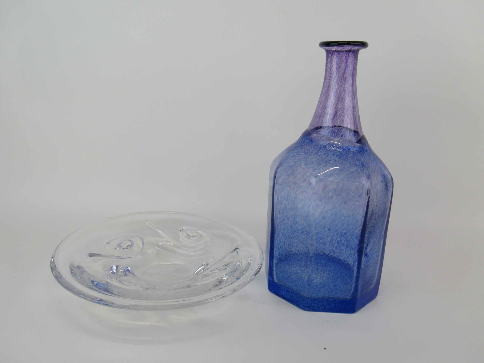 Bertil Vallien Kosta Boda Art Glass Bottle Vase: Bertil Vallien Kosta Boda Purple Blue Art Glass Bottle Vase standing 12 1/4" tall. Together with Kosta Goran Warff Center Bowl, minor scratches, 9 7/8" diameter. Used condition.