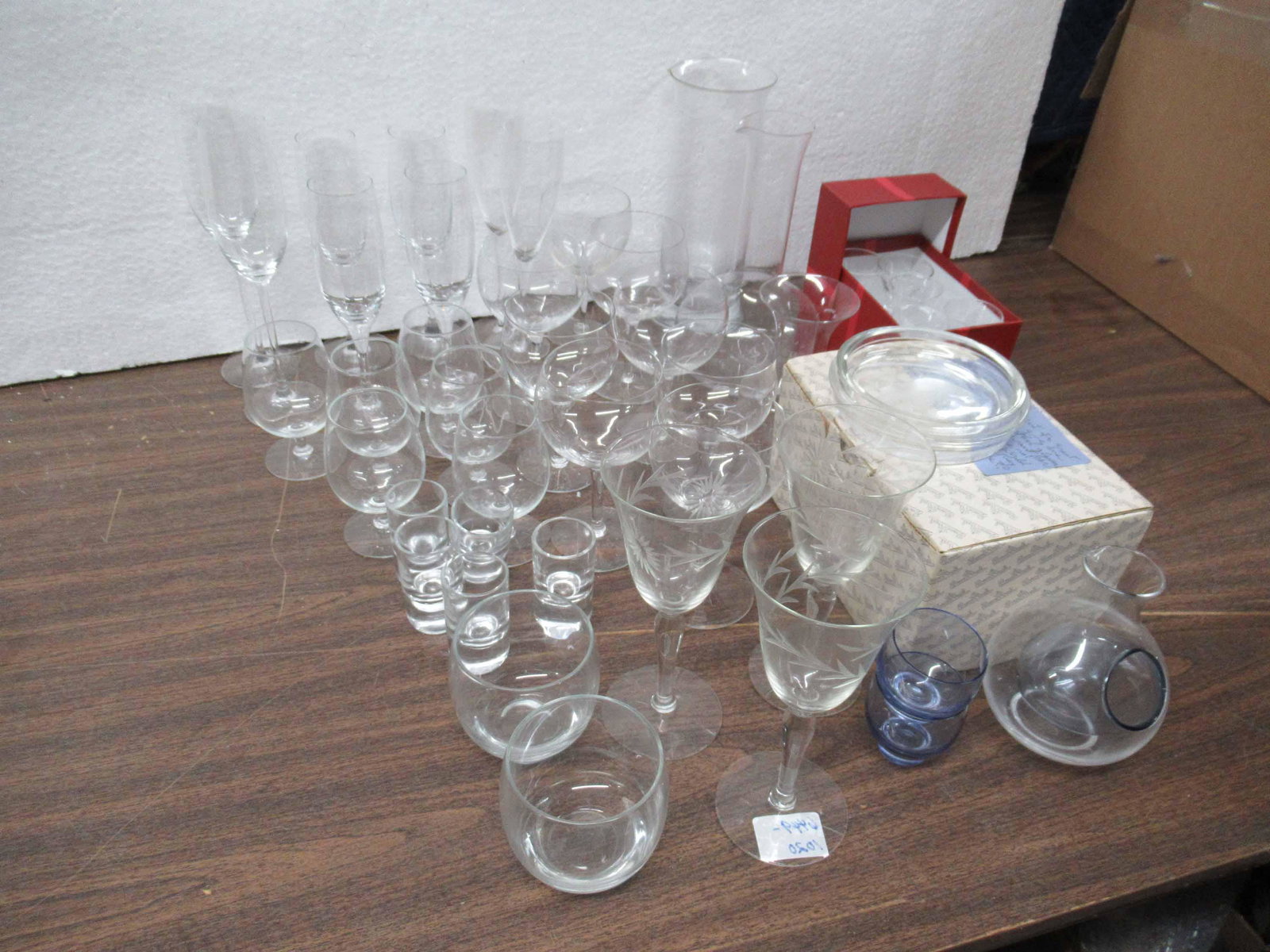Group of Assorted Glass Table Articles: Group of Assorted Glass Table Articles including a cold sake decanter bottle with two glasses, six boxed Rosenthal footed glasses, champagnes, wine stems, small snifters, shot glasses, cordials with m