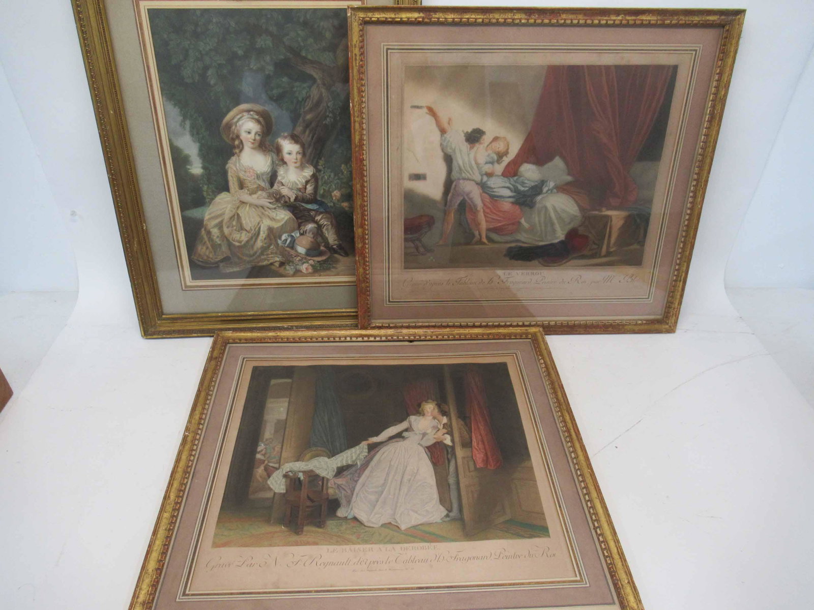 Group of Three Assorted Art Works: Group of Three Assorted Art Works including 2 continental children seated by a tree, "Le Verrou" and "Le Baiser a La Derobee". Used condition, wear, worn. Le Verrou framed size approx 24 1/2" wide x 2