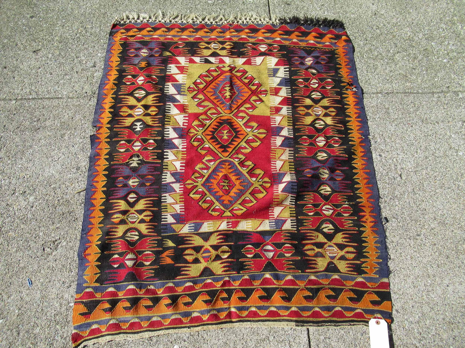 Kilm Throw Rug with Orange Tones: Kilm Throw Rug with Orange Tones. Used condition, wear, worn, damage, holes, tears. 4'10" x 4'1"
