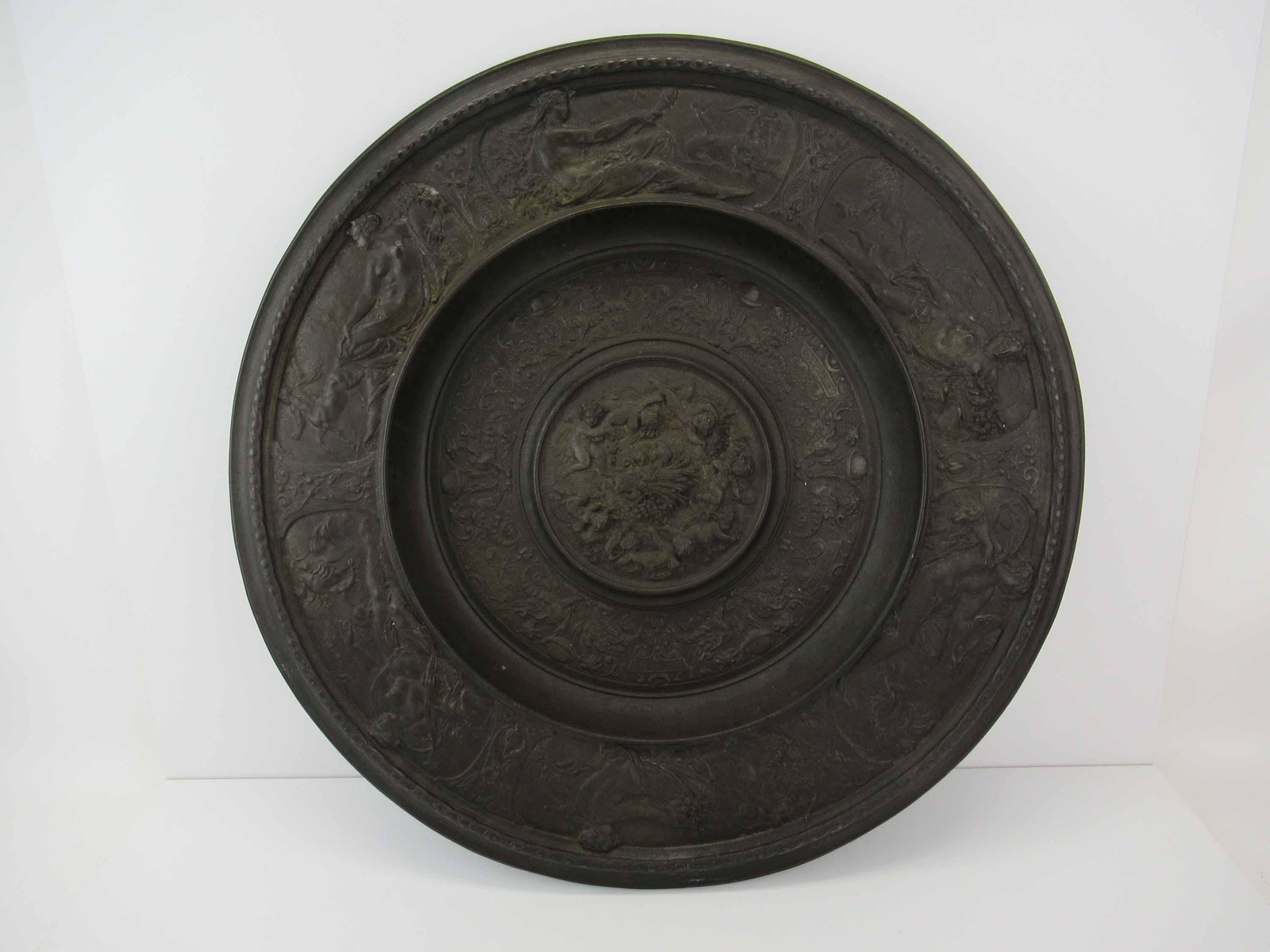 Large Baroque Style Cast Iron Charger with Relief: Large Baroque Style Cast Iron Charger with Relief depicting a central scene with putti, the months August -December and an outer rim of goddesses and animals, hallmark is illegible on verso; used cond