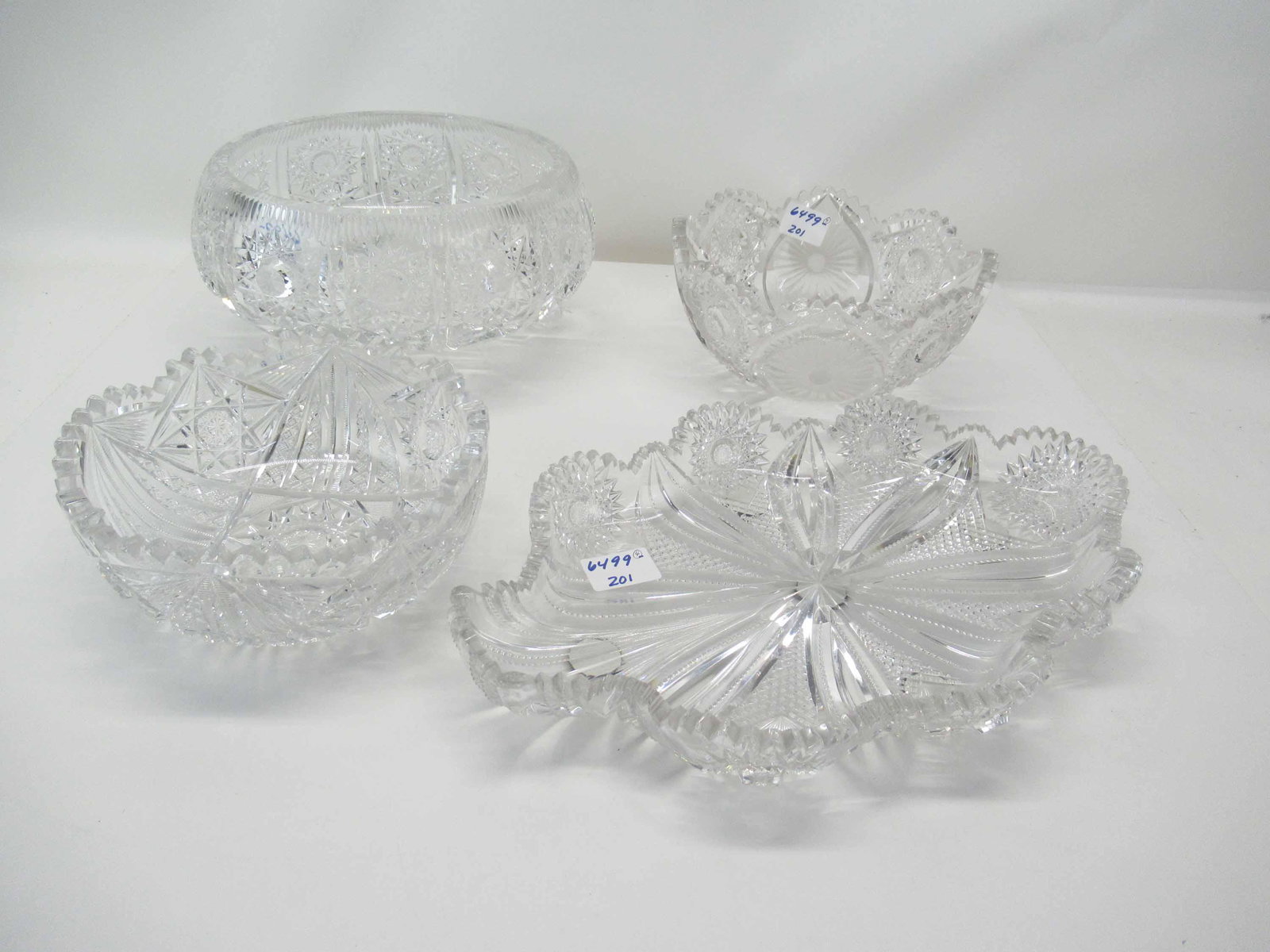 Group of Assorted ABP Cut Glass Table Articles: Group of assorted ABP Cut Glass Table Articles having saw-tooth rims including a large footed bowl, two smaller bowls and tray, Used condition, wear/worn, chips on the rims; footed bowl measures 11" i