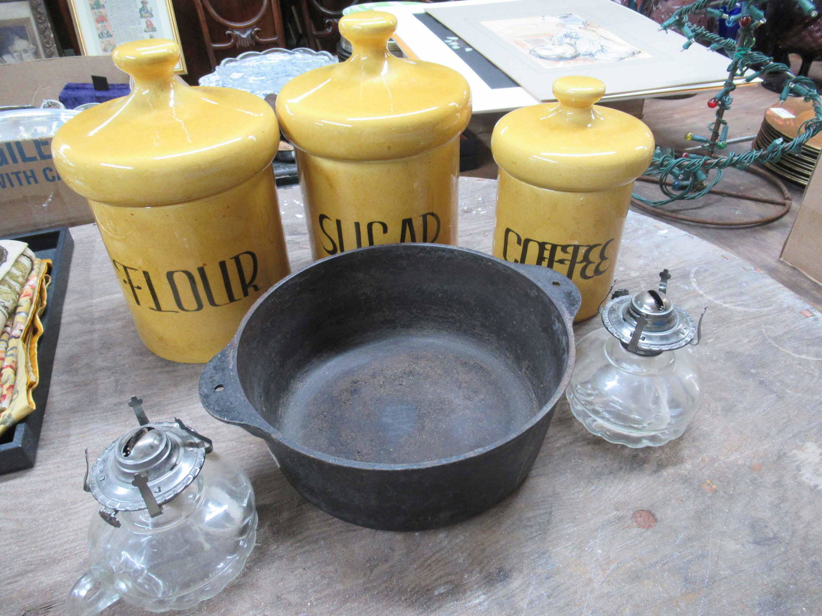 Griswold Cast Iron Kettle: Griswold Cast Iron Kettle. Together with 3 canisters and 2 fluid lamps. Used condition, wear, worn. Griswold size 4" tall x 10" diameter and 12" handle to handle.