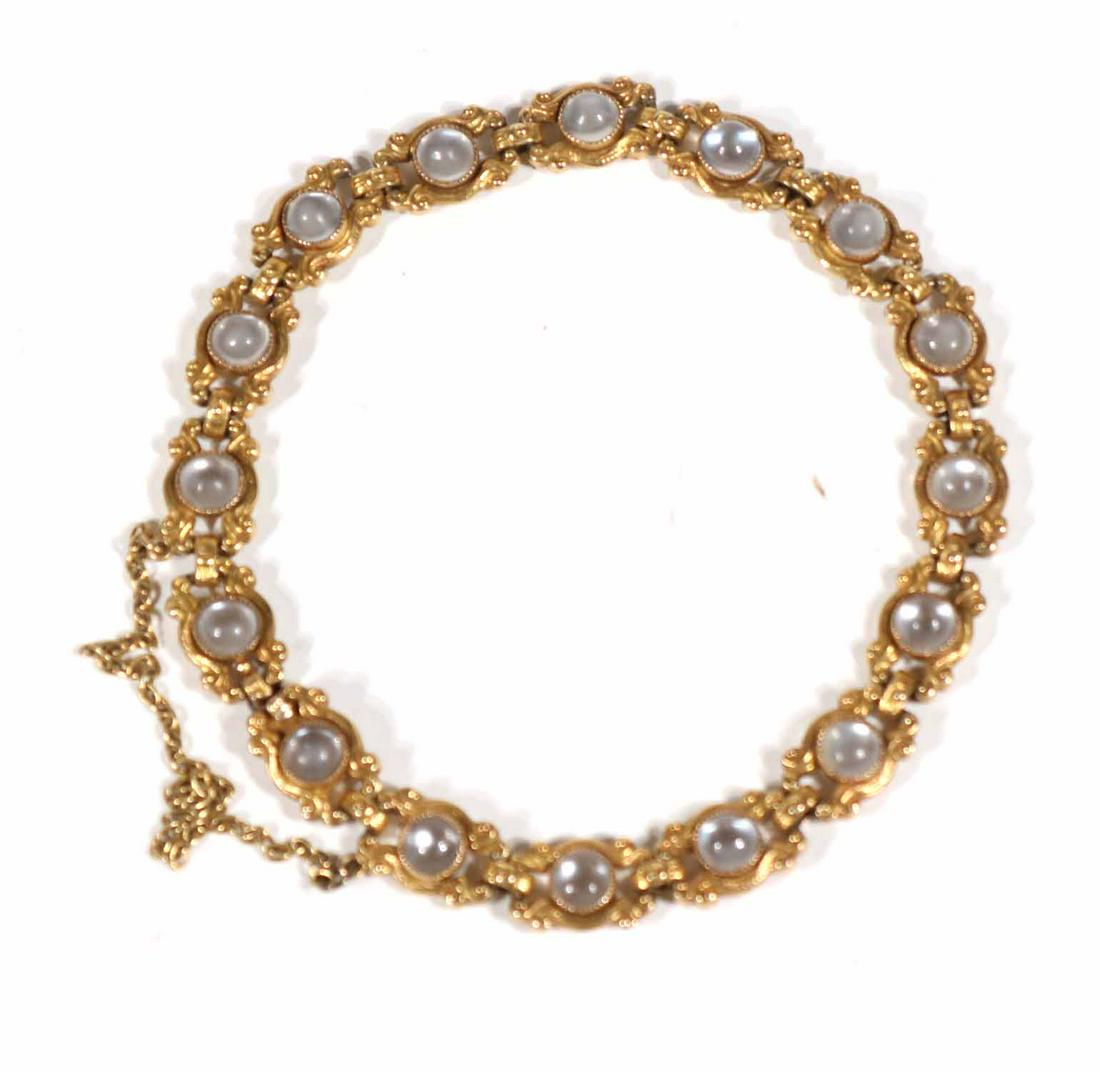 Art Nouveau Yellow Gold & Moonstone Link Bracelet: Stamped 14, containing sixteen round moonstone set links, with safety chain, approx. 7"l, gross total weight approx. 7.9dwt.