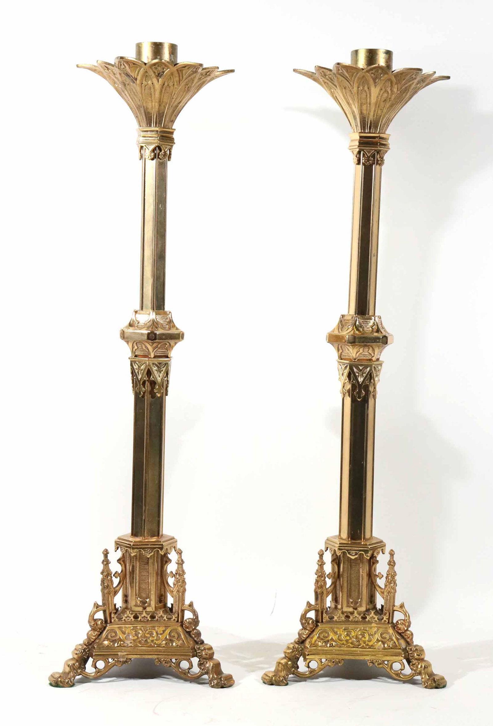 Pair of Victorian Gothic-Revival Candlesticks: English or American, late 19th/20th C. brass, each lacking one finial on base. 24"h x 9"dia.