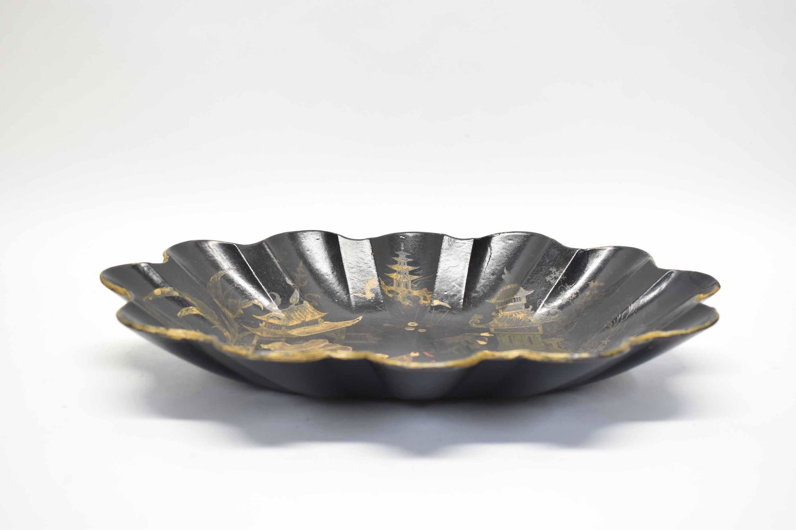 Chinoiserie Papier Mache Scallop Bowl: Chinoiserie Papier Paper Mache Scallop form oval bowl with black ground, gilt decoration including men and pagodas; used condition, wear/worn, repaired edge, measures 13 3/4" long x 10 1/4" wide x dia