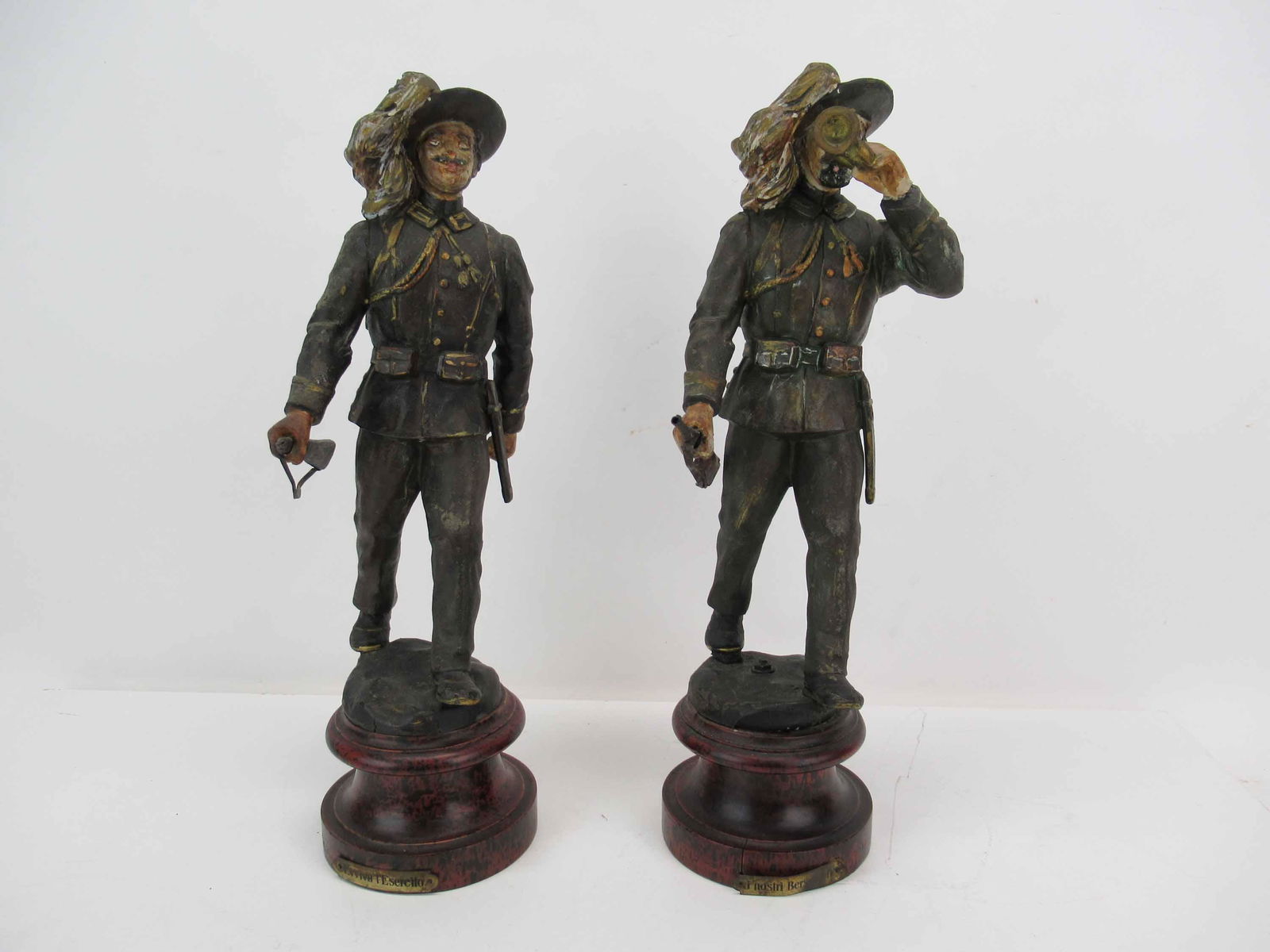 Two Italian Bersaglieri Army Soldier Statues: Two Italian Bersaglieri Army Soldier Figures mounted on wood bases, made of patinated metal; used condition, wear/worn, losses, splits to wood, one metal plate is missing nail, measures 14 1/2" high x