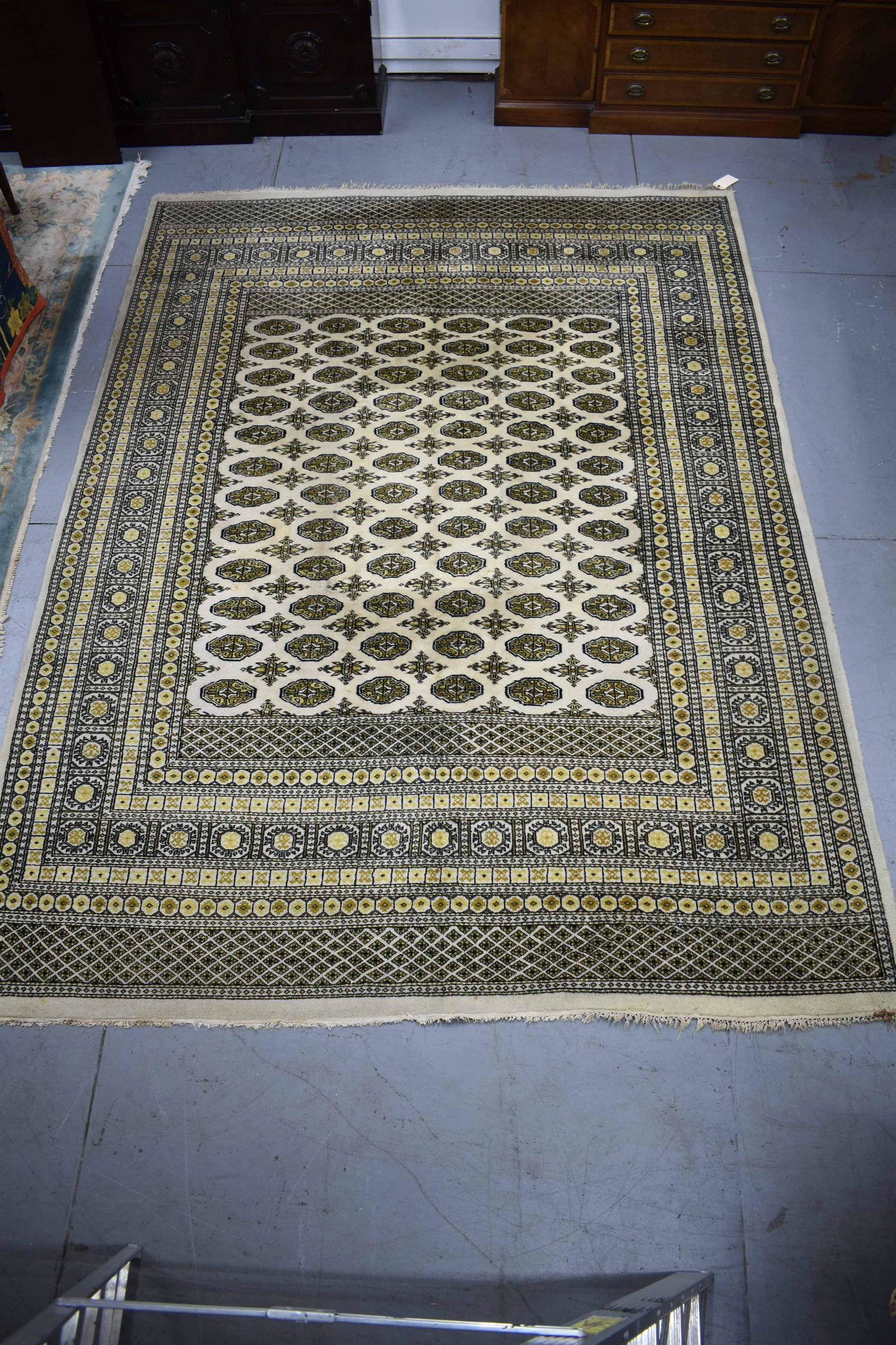 Bukhara Hand Knitted Room Size Rug: Bukhara Hand Knitted Room Size Rug made in India for m/s R. H. Macy & Co. Having all over gold, cream and black design. Used condition, wear, worn, stains, fringe loss. 8'4" wide x 11'5" long