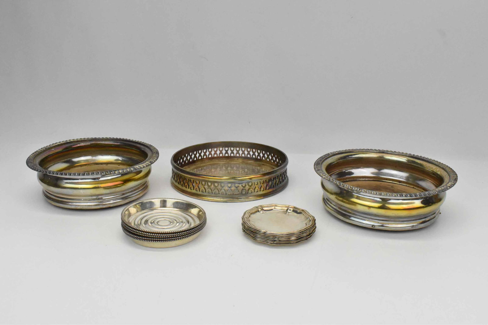 John Seymour Silverplate Wine Coaster: John Seymour Silverplate Wine Coaster with pierced sides, stamped 1405 Made in England, together with two wine coasters with wood bases, 5 Friedman silverplate small nut dishes and 7 small nut dishes