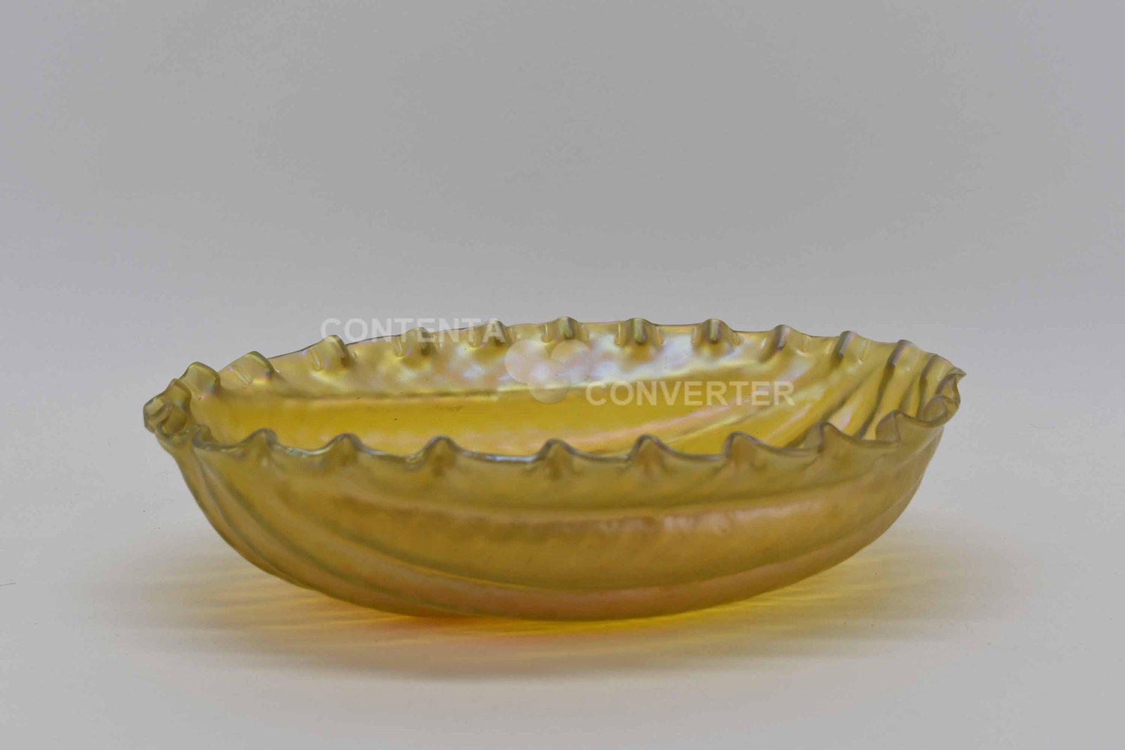 Loetz Style Gold Iridescent Bowl: Loetz Style Gold Iridescent Bowl having a melon shape form with ribbed sides, scalloped rim and smooth pontil; used condition, wear/worn, scratching to the base, measures 12 1/4" long x 9 1/4" wide x 