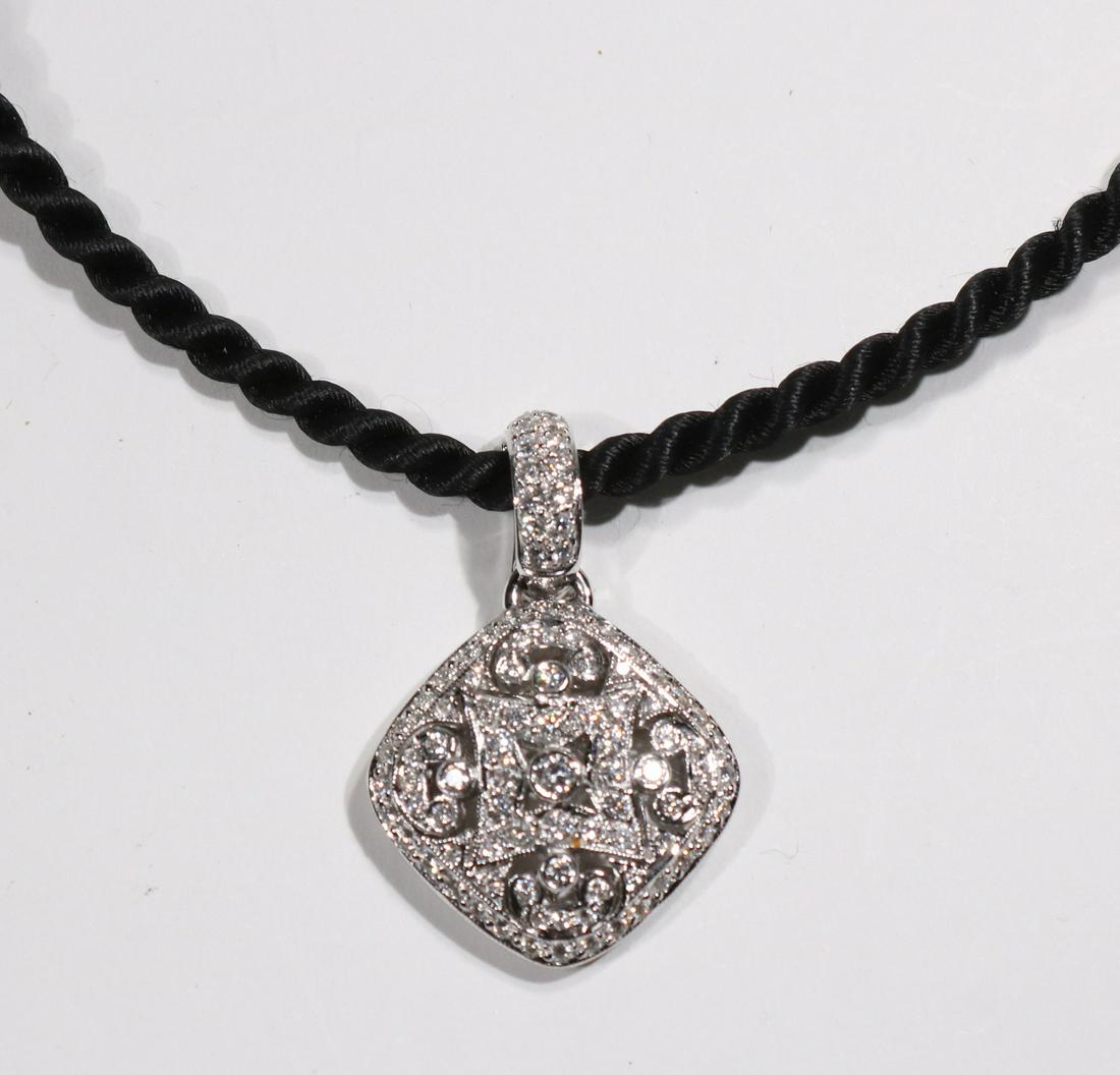 Vintage Style Filigree Diamond Enhancer: A VINTAGE STYLE FILIGREE DIAMOND ENHANCER WITH PAVE BAIL in 18k white gold, on black cord METAL: 18 Karat white gold STONES: diamonds weighing approximately 1.50 carats total SIGNATURE: A & G with ser