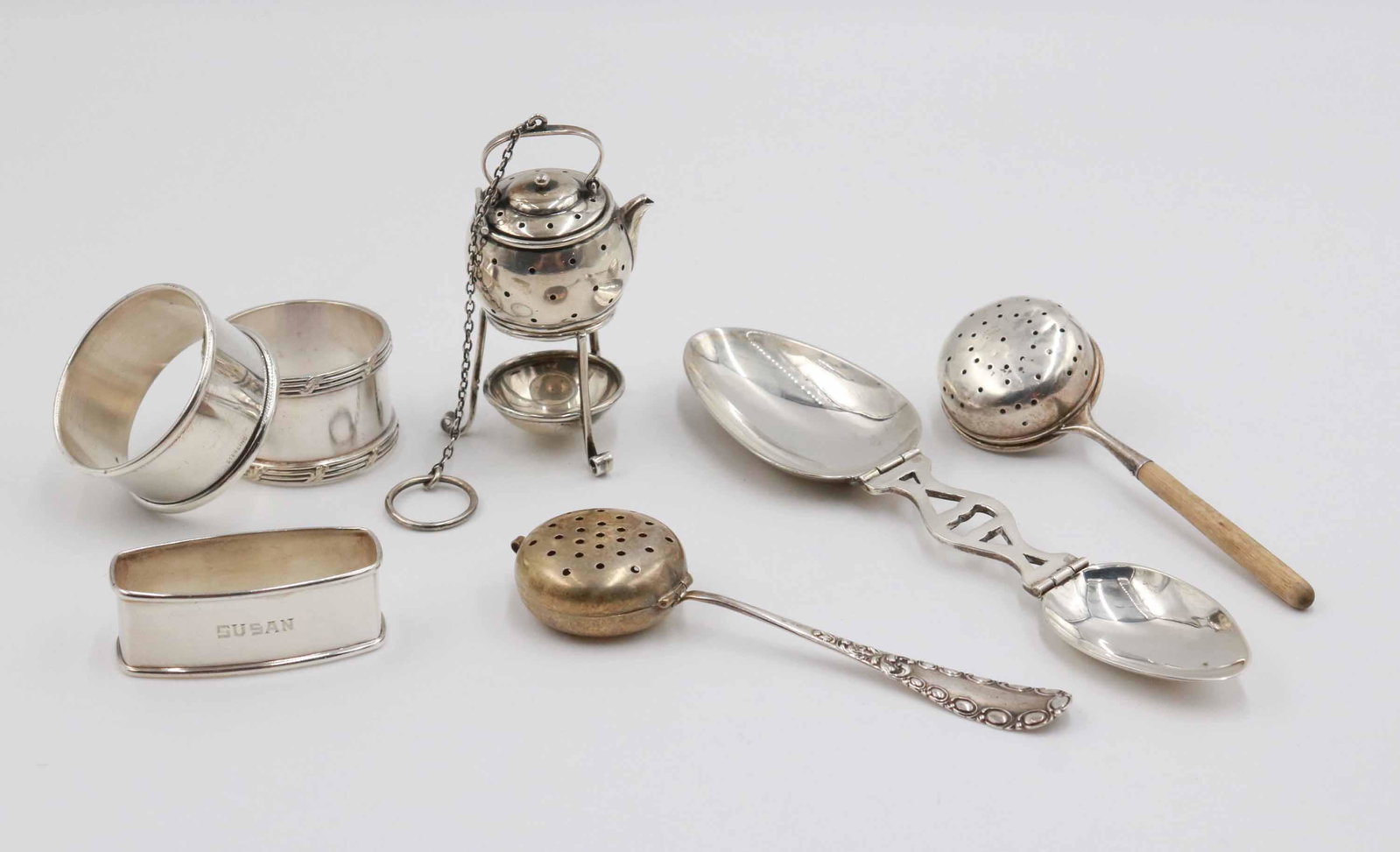 Two Vintage Sterling Silver Napkin Rings: Together with a silver plated napkin ring, a sterling silver folding travel or medicine spoons, a sterling tea strainer kettle on stand (top kettle unmarked), and two sterling long handled tea straine