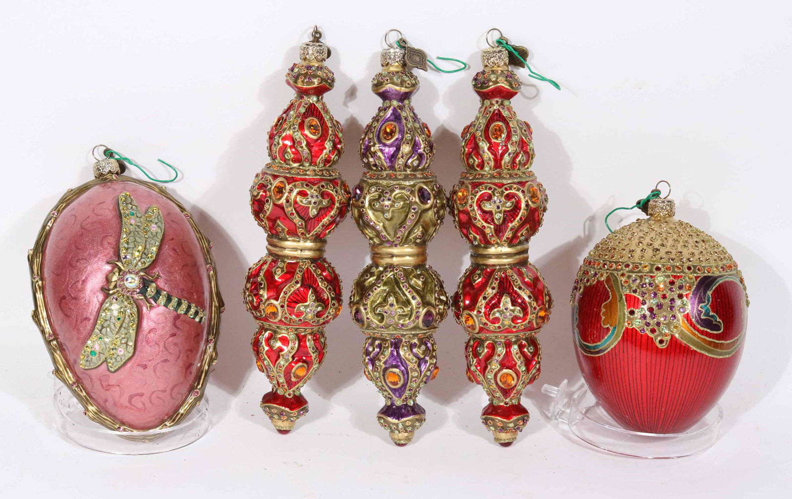 Five Jay Strongwater Crystal Christmas Ornaments: Comprising, one red egg form, two red and gold finial form, a purple finial form, and a dragonfly decorated pink egg form. All with original boxes. Apx. 5-1/2"h to 7-1/2"h Property from a Short Hills,
