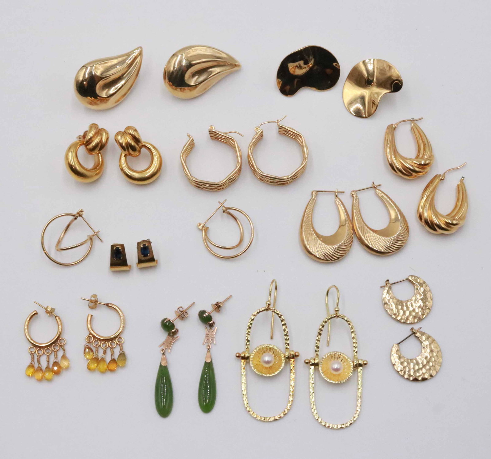 Ten Pair Unmarked 14K Yellow Gold Earrings: Comprising hoops, swirl style, one pair of chrysoprase drop pendant, and one small partial hoop each set with blue spinel, total weight approx. 27.3dwt, earrings with stones not included in weight, ra