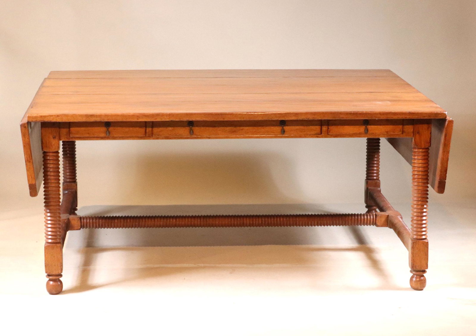 Jacobean Style Maple Drop Leaf Center Table: English Taste, 20th C. of impressive side, fitted with frieze drawers. 30-1/2"h x 6'4"w (closed) x 8'4"w (open) x 5'd Provenance: Property from the Estate of William Hodgins, Boston, Massachusetts