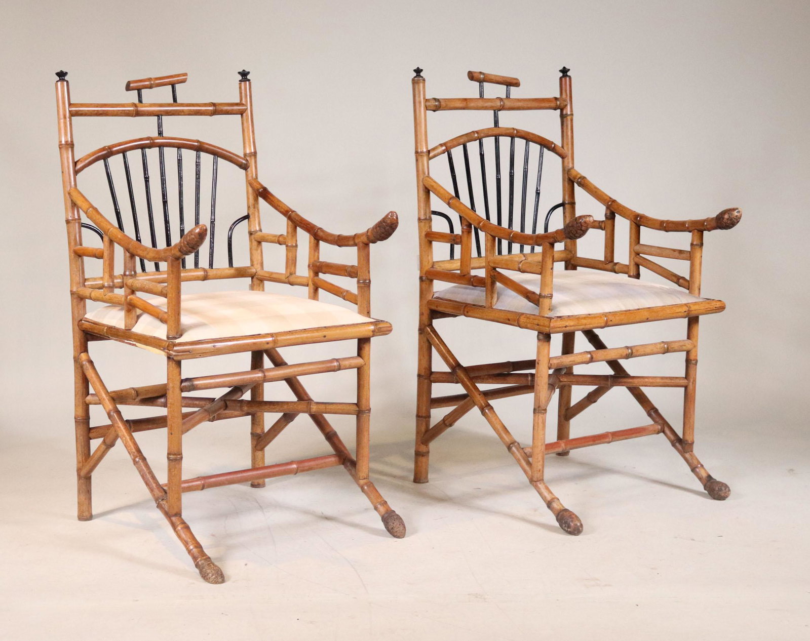 Pair of Part-Ebonized Bamboo Armchairs: Probably Chinese, 19th C. Upholstery of a later date, some distress. 39-1/2"h x 21-1/2"w x 19-1/2"d (seat)