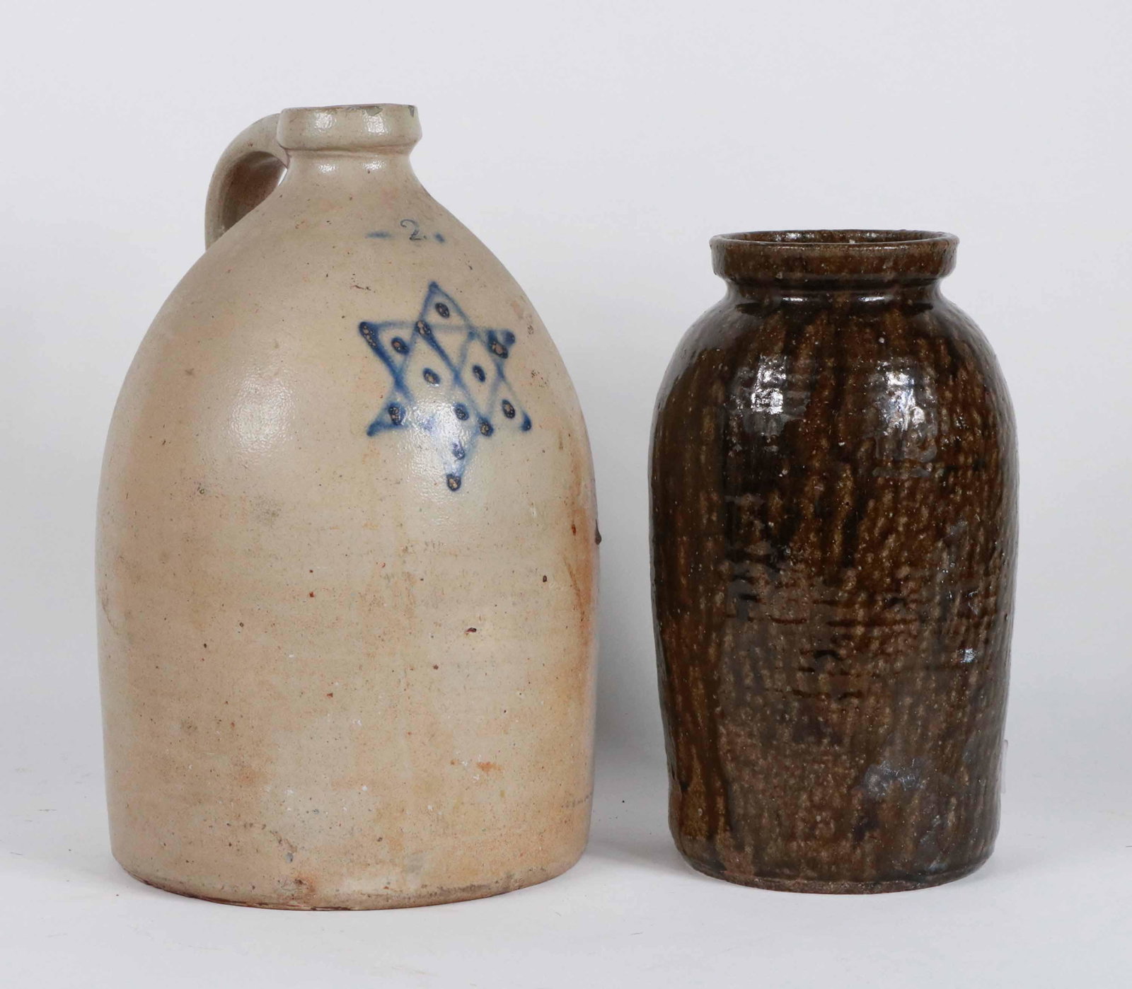 Two Gallon Six-Point Star Stoneware Jug: American, 19th C. cobalt decorated. Together with an alkaline-glazed earthenware pot, probably American, 19th C. Jug: 14"h Pot: 11-1/2"h Provenance of Cobalt-Decorated Jug: R & M Leed Antiques, Wappin