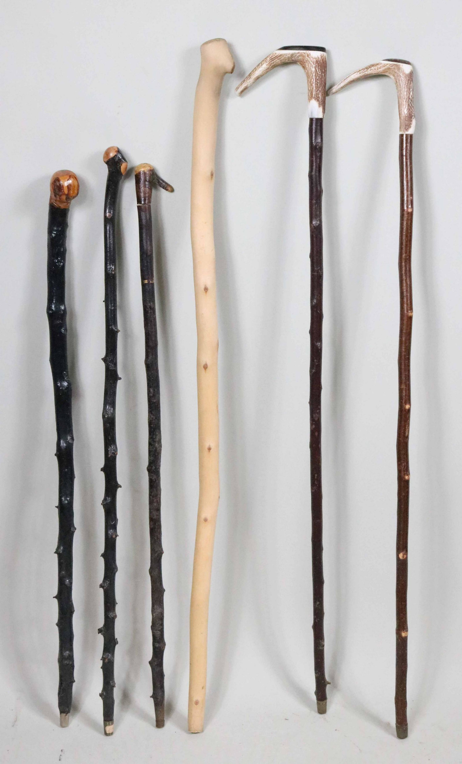 Three Victorian Briarwood Canes: 19th/20th C. one stamped with a three-leaf clover. Together with two antler handled canes and a barkless wood cane. 6 pieces. Provenance: Property from the Steve and Stephanie Alpert Collection