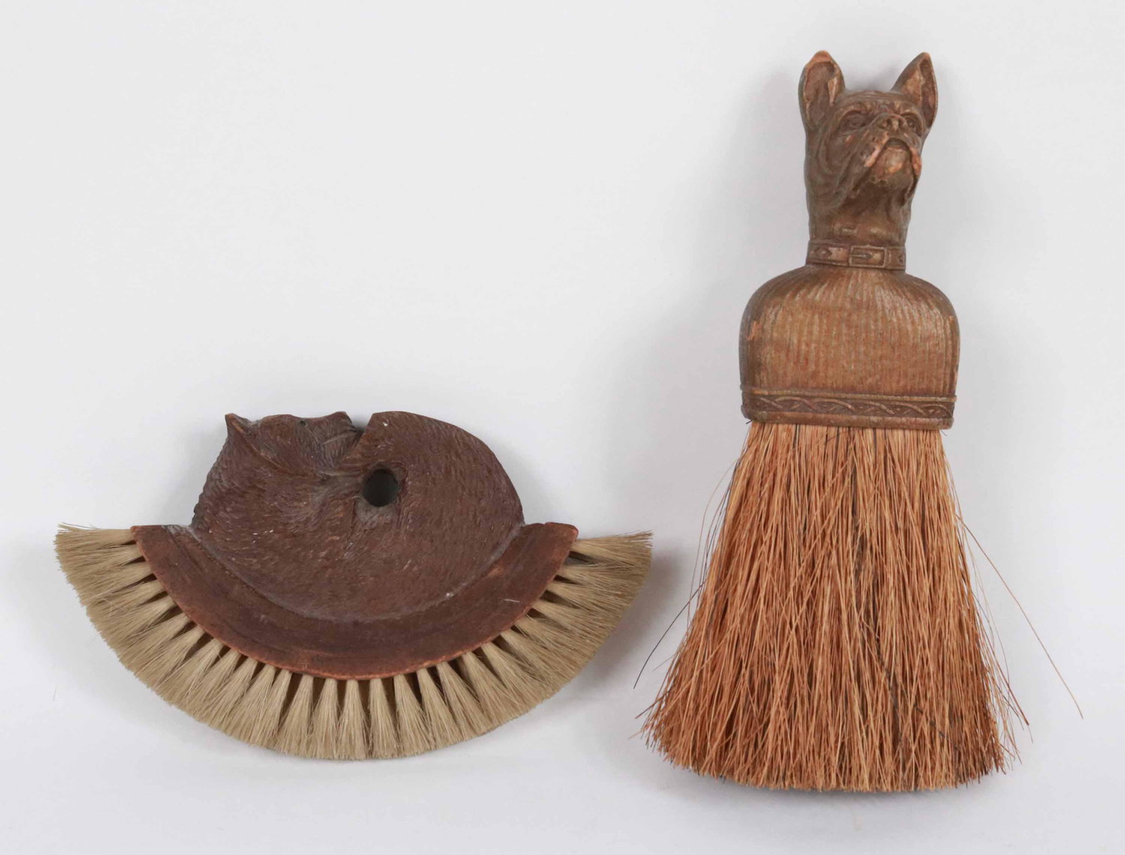 Black Forest Walnut Bear-Decorated Clothes Brush: 19th/20th C. Together with a carved and painted Boxer dog head brush. Bear: 3-3/4"h x 6-1/4"w Dog: 7-3/4"l Provenance: Property from the Siegmund Collection of Folk Art, New York, New York Additional 