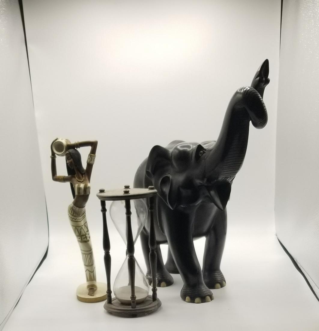 Group of Assorted African themed Table Articles: Group of Assorted African themed Table Articles including a hourglass, statue of woman dancing and large/semi-heavy elephant made of condensed wood. Losses and repairs to Elephant. Approx. 17"tall.