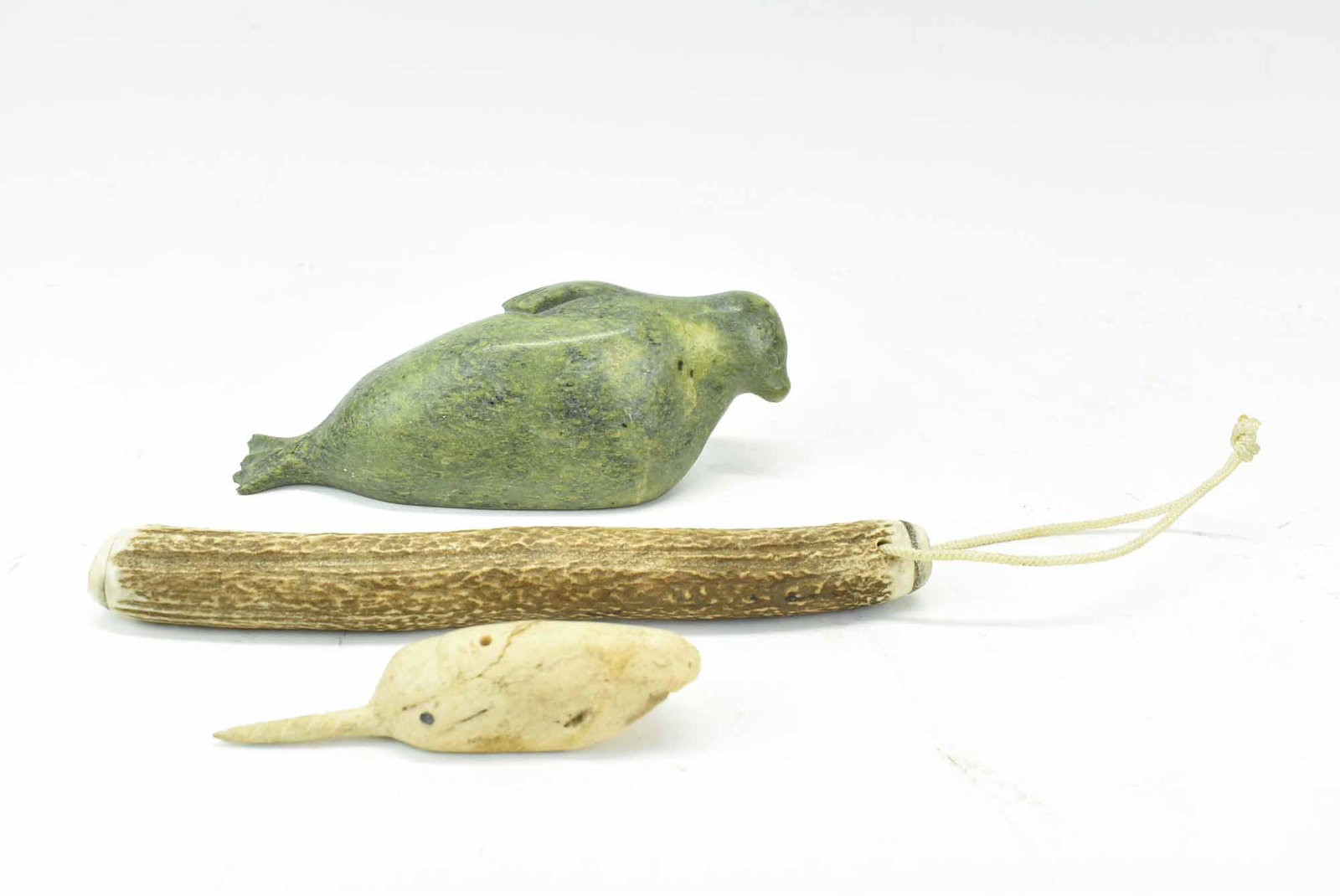 Weighted Antler Club: Weighted Antler Club, weighted at one end, together with a carved bone partial narwhal and an Inuit carved soapstone sea lion, signed; used condition, wear/worn, club measures 8 3/4" long x 1" in diam
