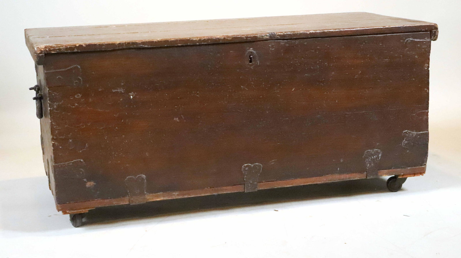 Brown Painted Pine Foot Locket: English, 19th C. with paper lined top, on casters. Gouges, wear, losses. 20-1/2"h x 46"w x 21"d